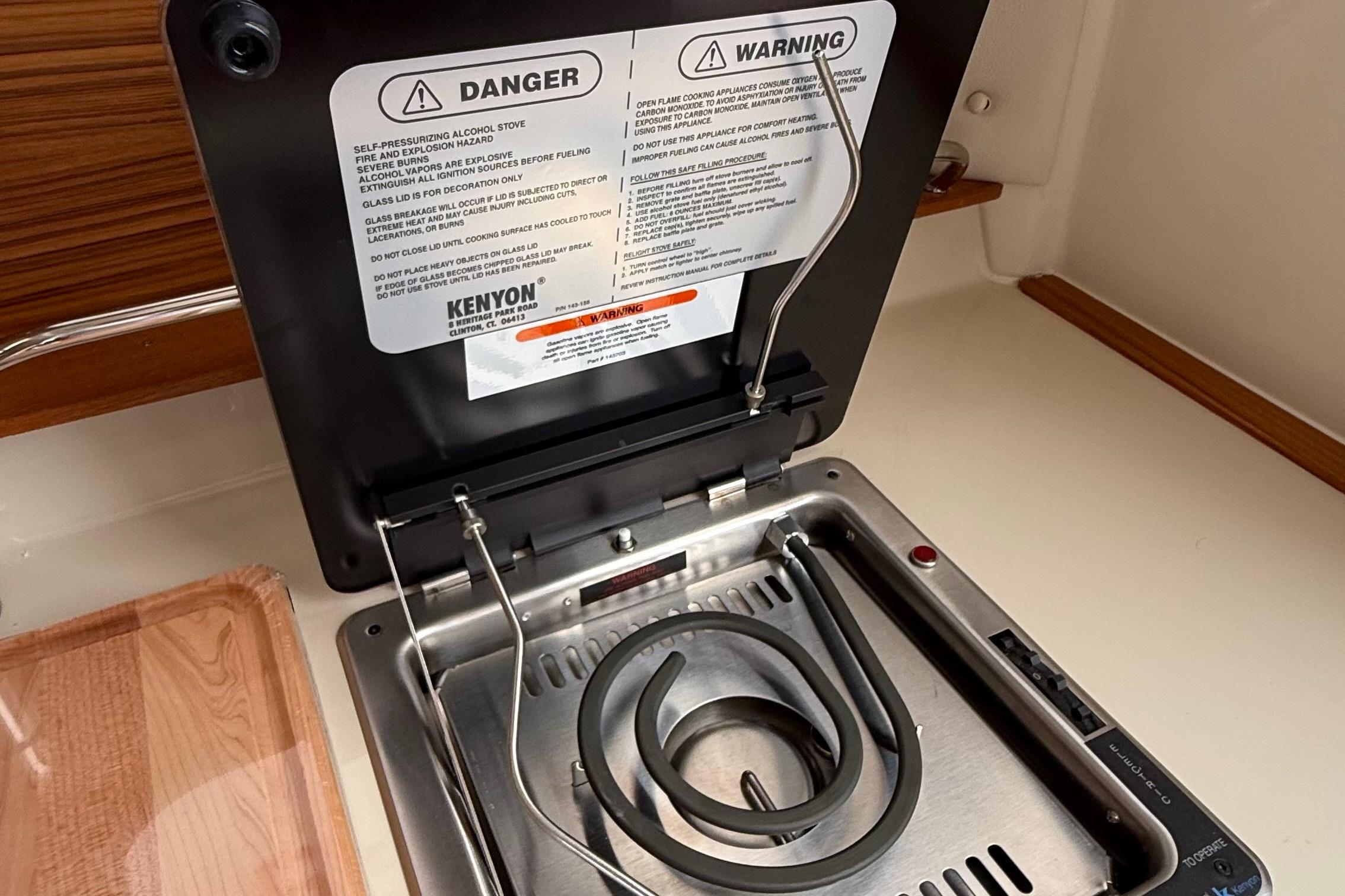 Electric stove in 2025 Ranger Tugs R-25 boat galley with safety warnings displayed.