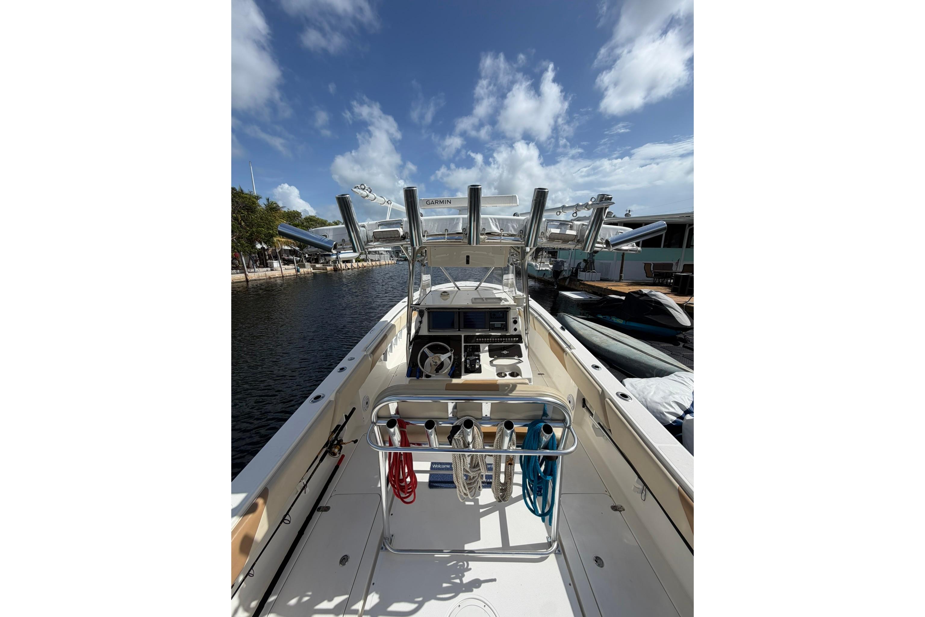 2007 Fountain 34 Center Console boat docked under a clear blue sky.