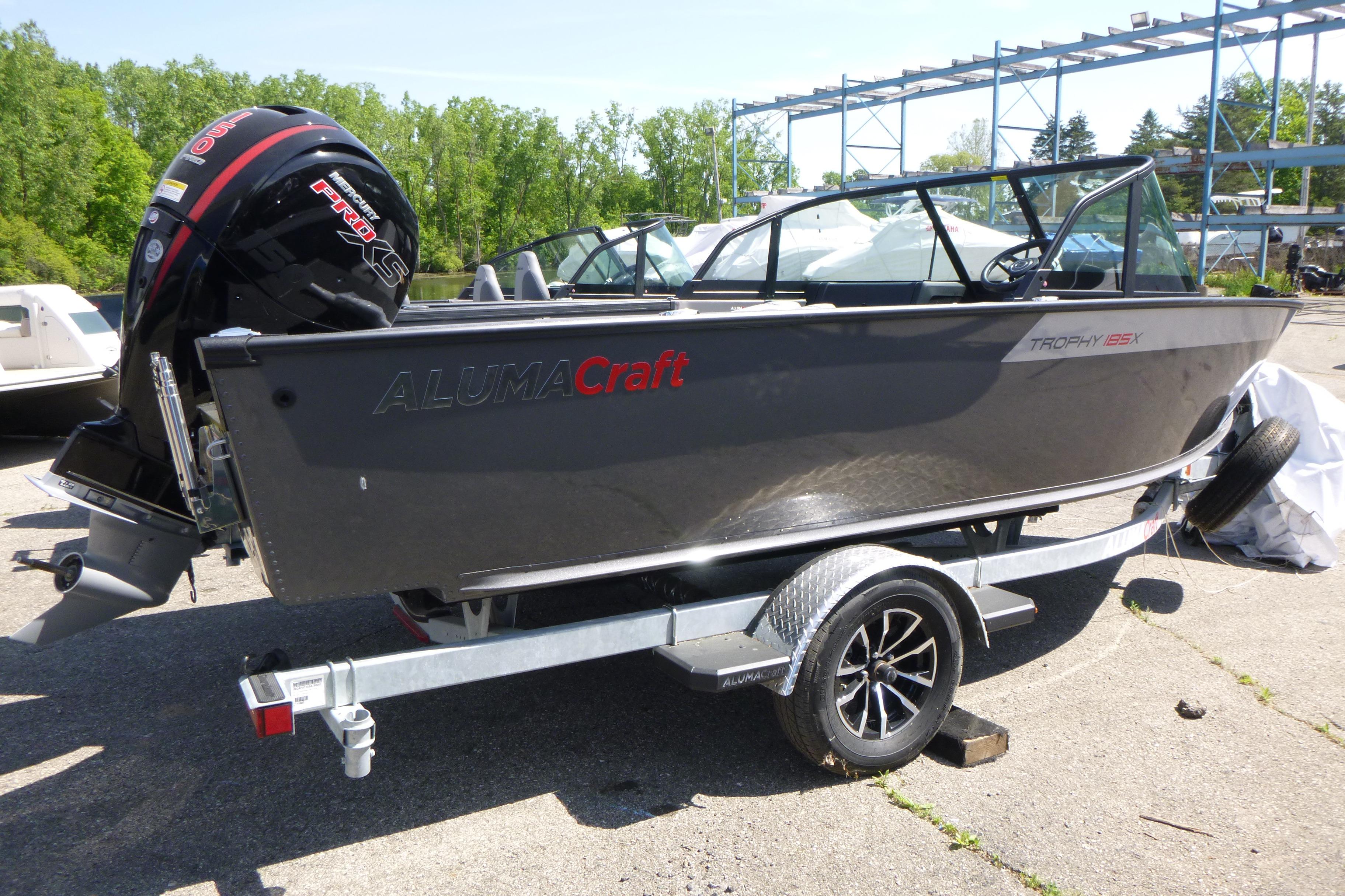 2025 Alumacraft Trophy 185X Sport boat on trailer, outdoors in sunny setting.