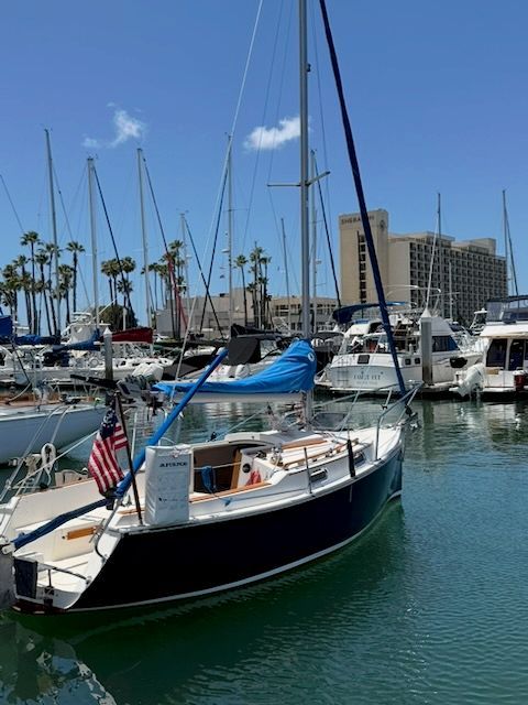2006 Com-Pac Eclipse sailboat docked in marina with palm trees and buildings in background.