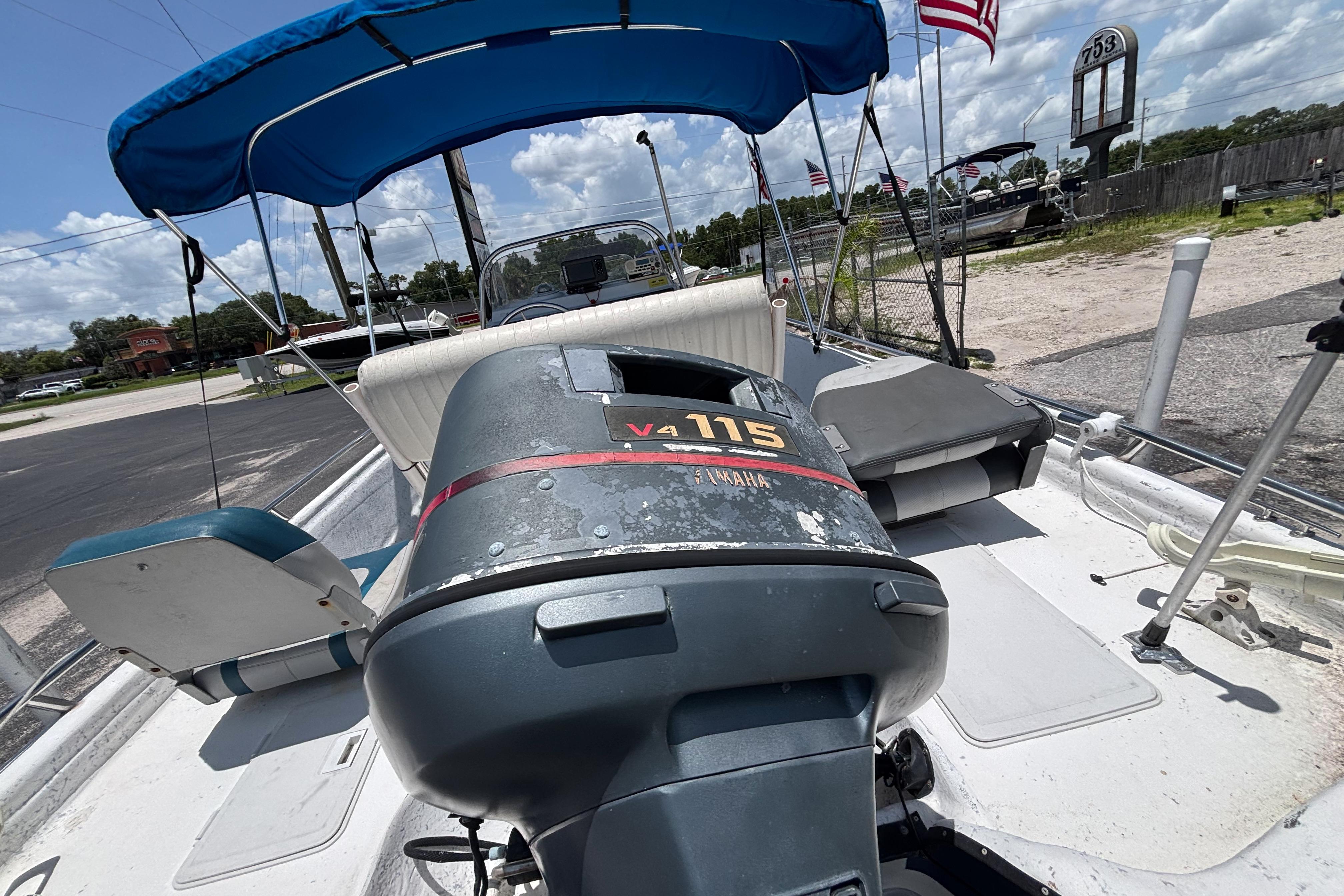 2000 VIP 1880 Bay Stealth boat with Yamaha V4 115 engine, blue canopy, and American flag.