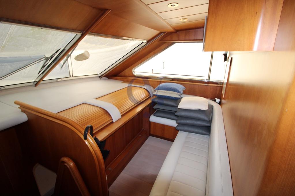 Interior of 1996 Canados 23 yacht with wooden paneling and cushioned seating.