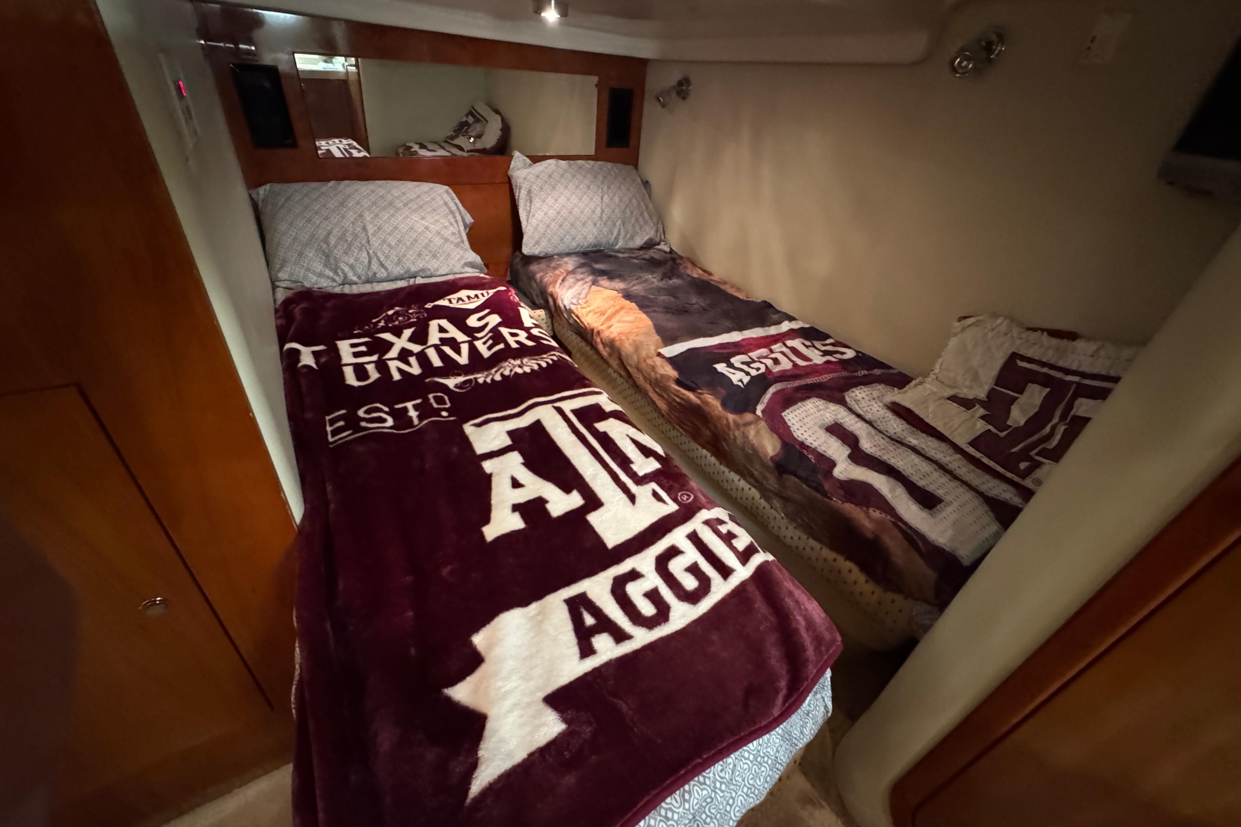 Twin beds in a 2005 Regal Commodore 4260 cabin with Texas-themed blankets.