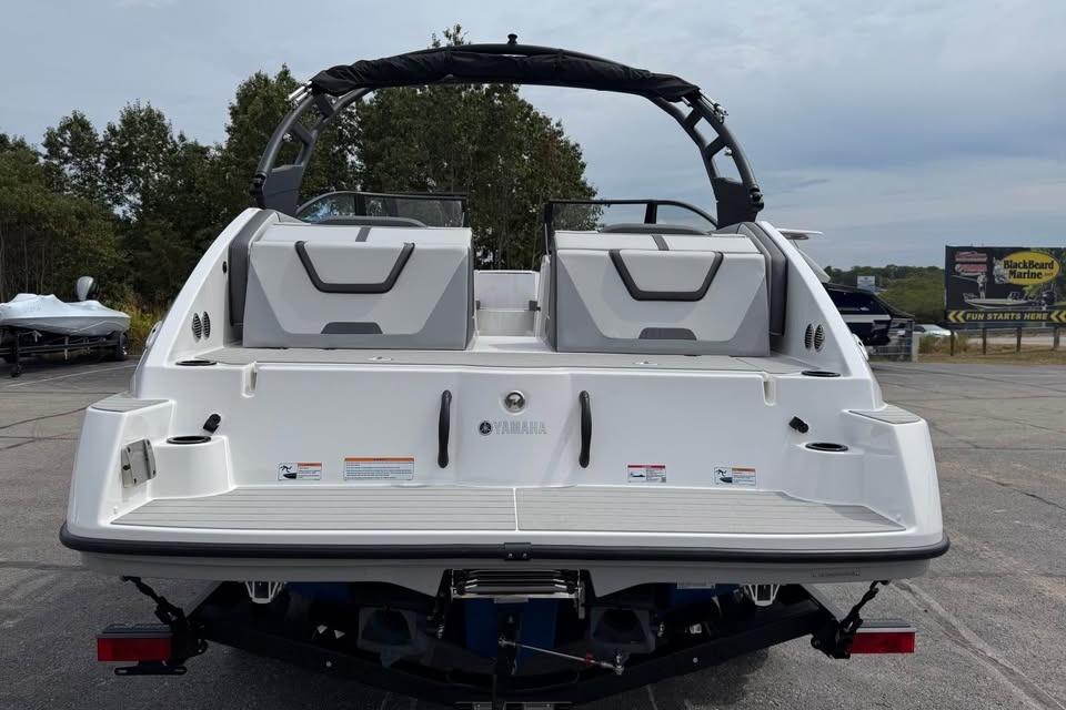 2026 Yamaha Boats AR220, rear view, parked outdoors with trees in background.