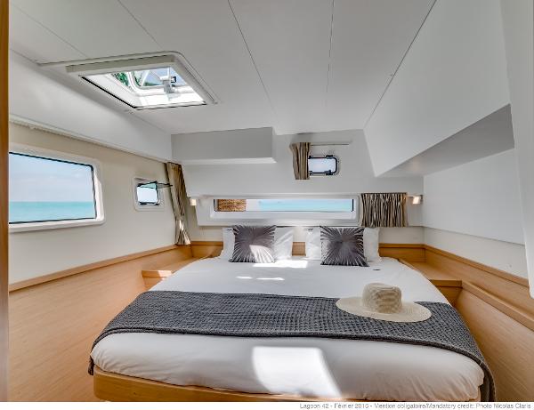 Luxurious bedroom interior of 2025 Lagoon 42 Millenium yacht with ocean view.