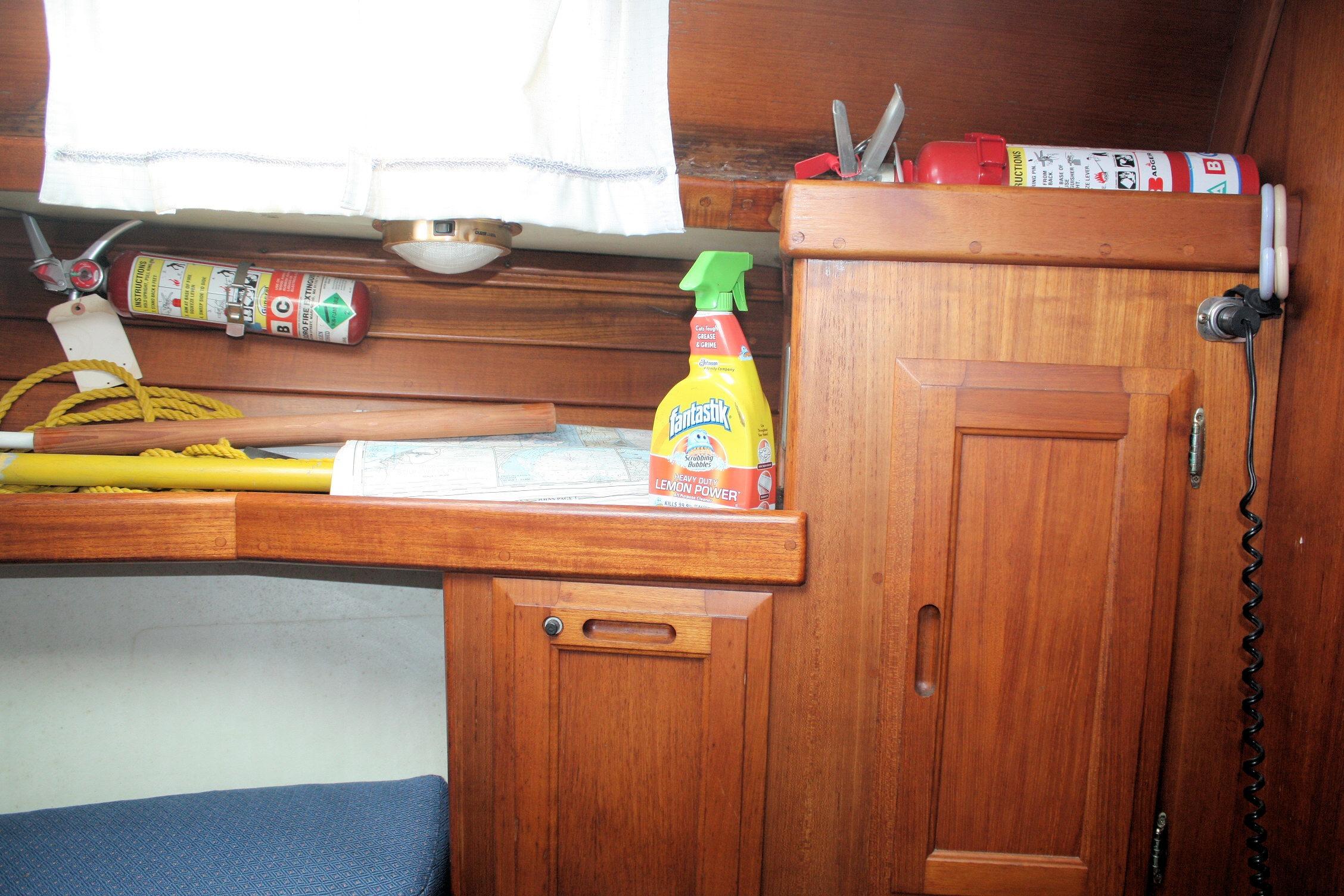 Interior of 1987 Ericson 38-200 sailboat with cleaning supplies and fire extinguishers.