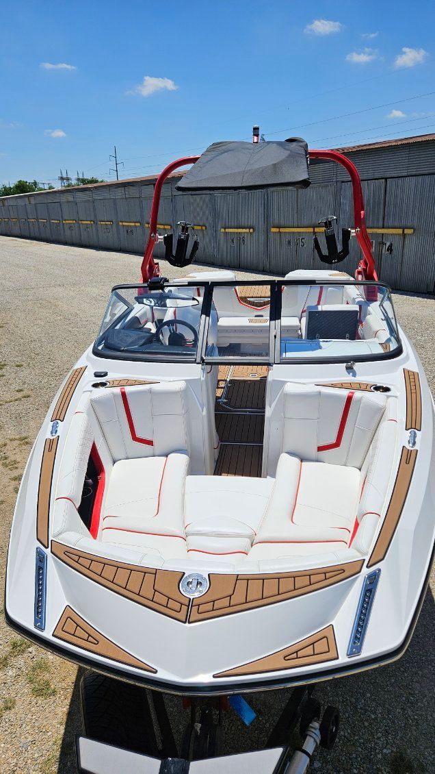 A 2018 Nautique Super Air Nautique G23 with white and red interior, parked on a trailer.