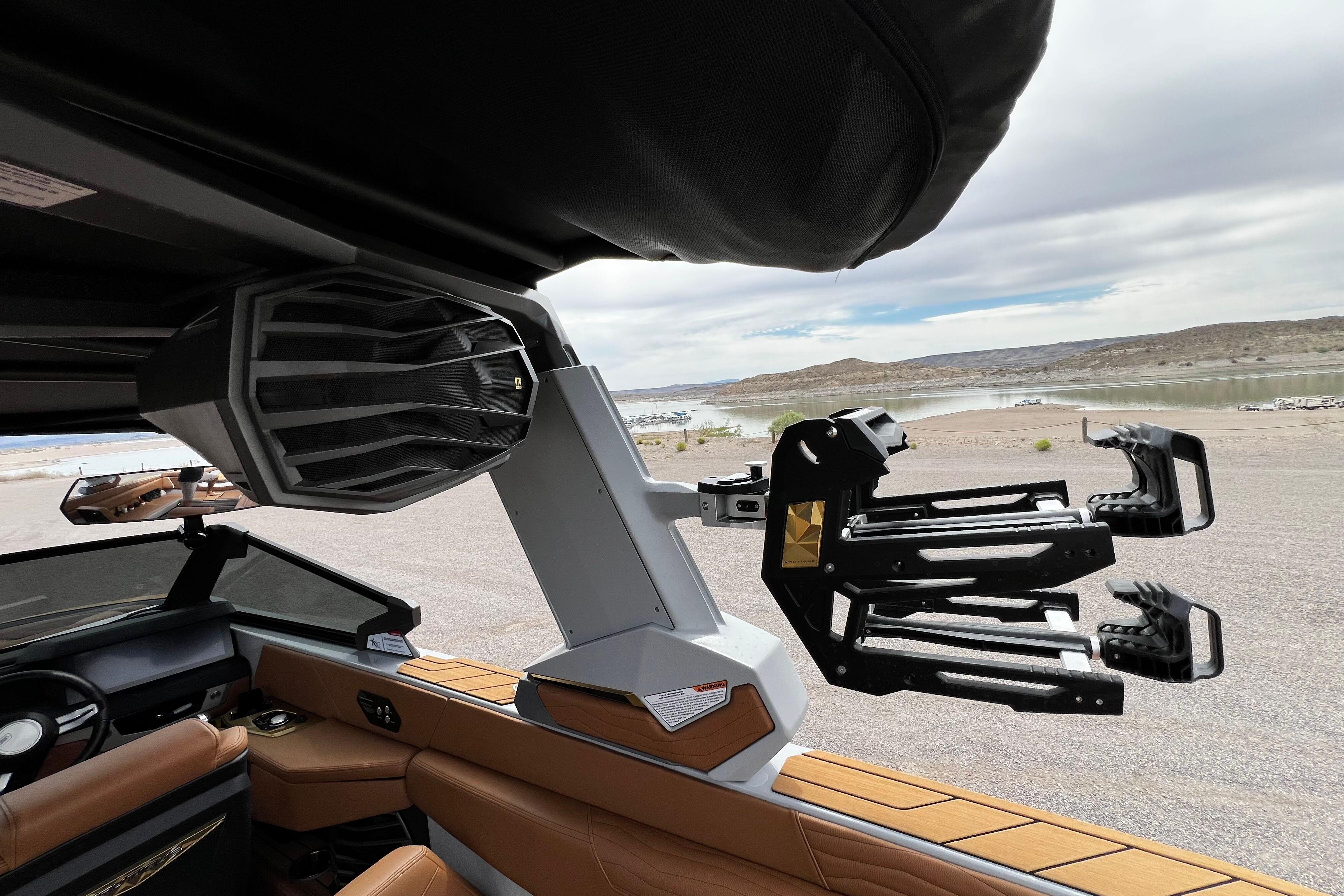 2026 Nautique Super Air Nautique G25 interior with speaker and wakeboard rack, lakeside view.