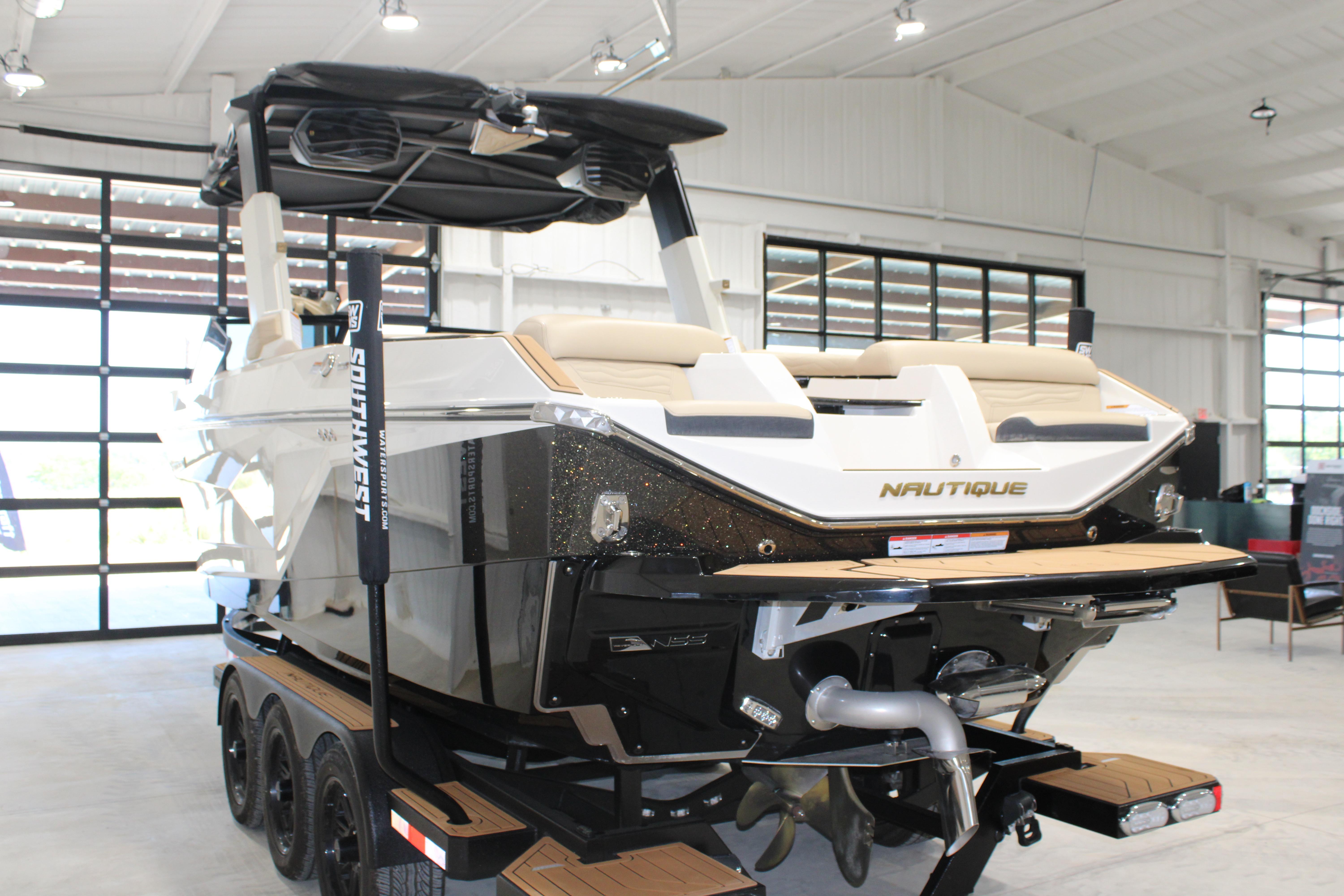 2025 Nautique Super Air Nautique G25 boat in a showroom, rear view.
