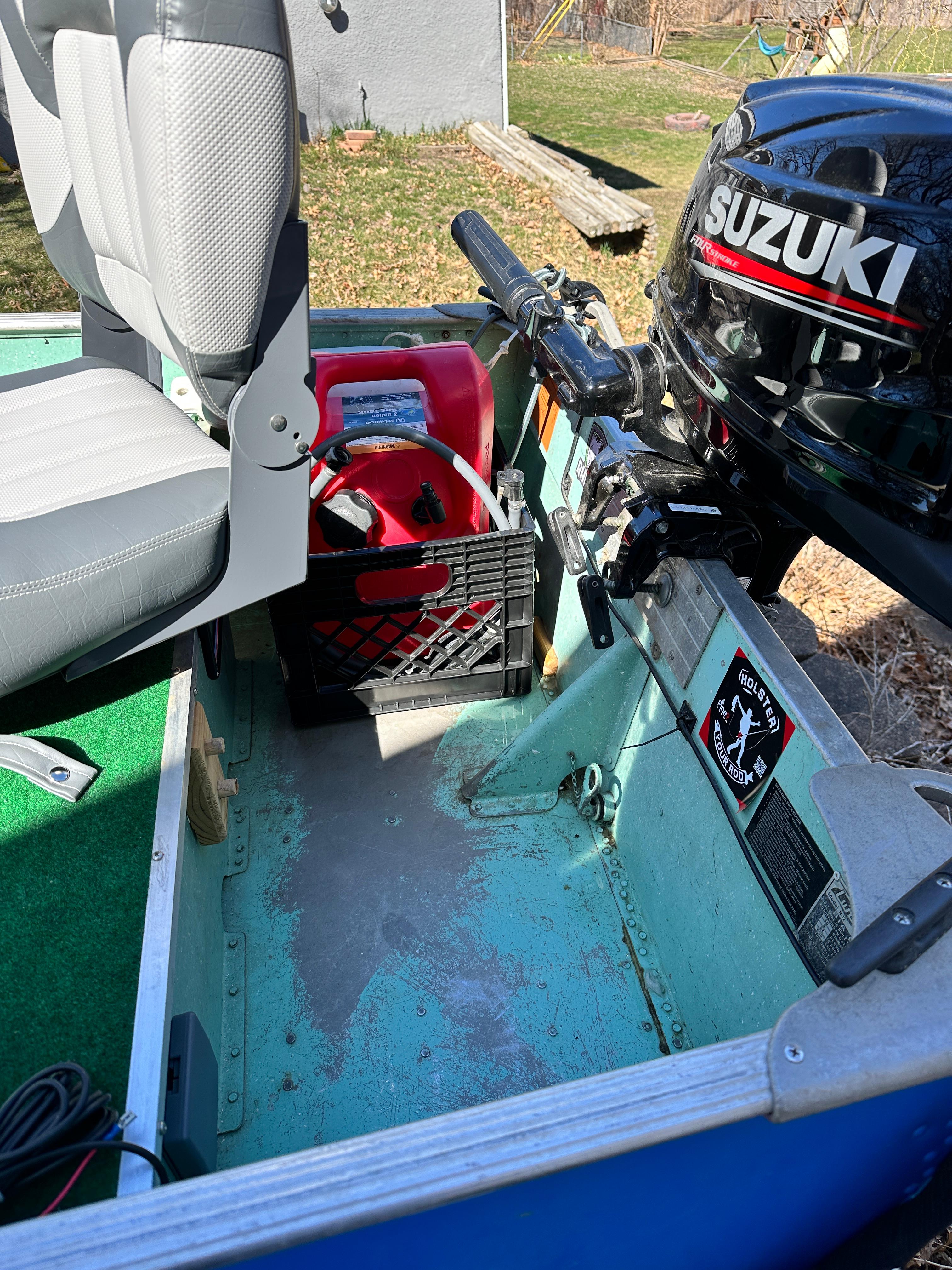 1960 Lund H boat interior with Suzuki motor and red fuel tank.