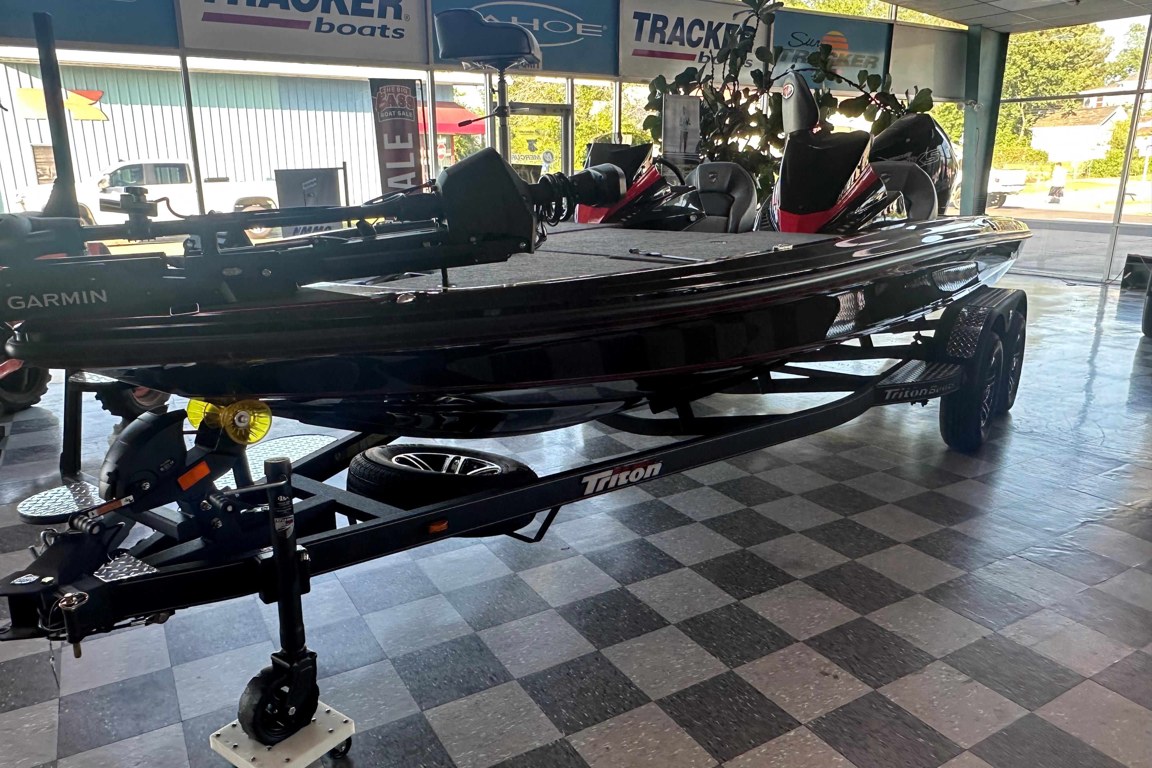 2026 Triton 20XP Patriot boat displayed in showroom with Garmin equipment.