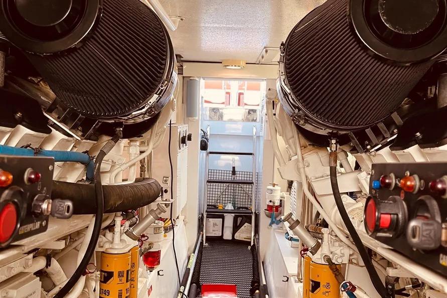 Engine room of 2003 Hatteras 60 Convertible yacht, showcasing machinery and controls.