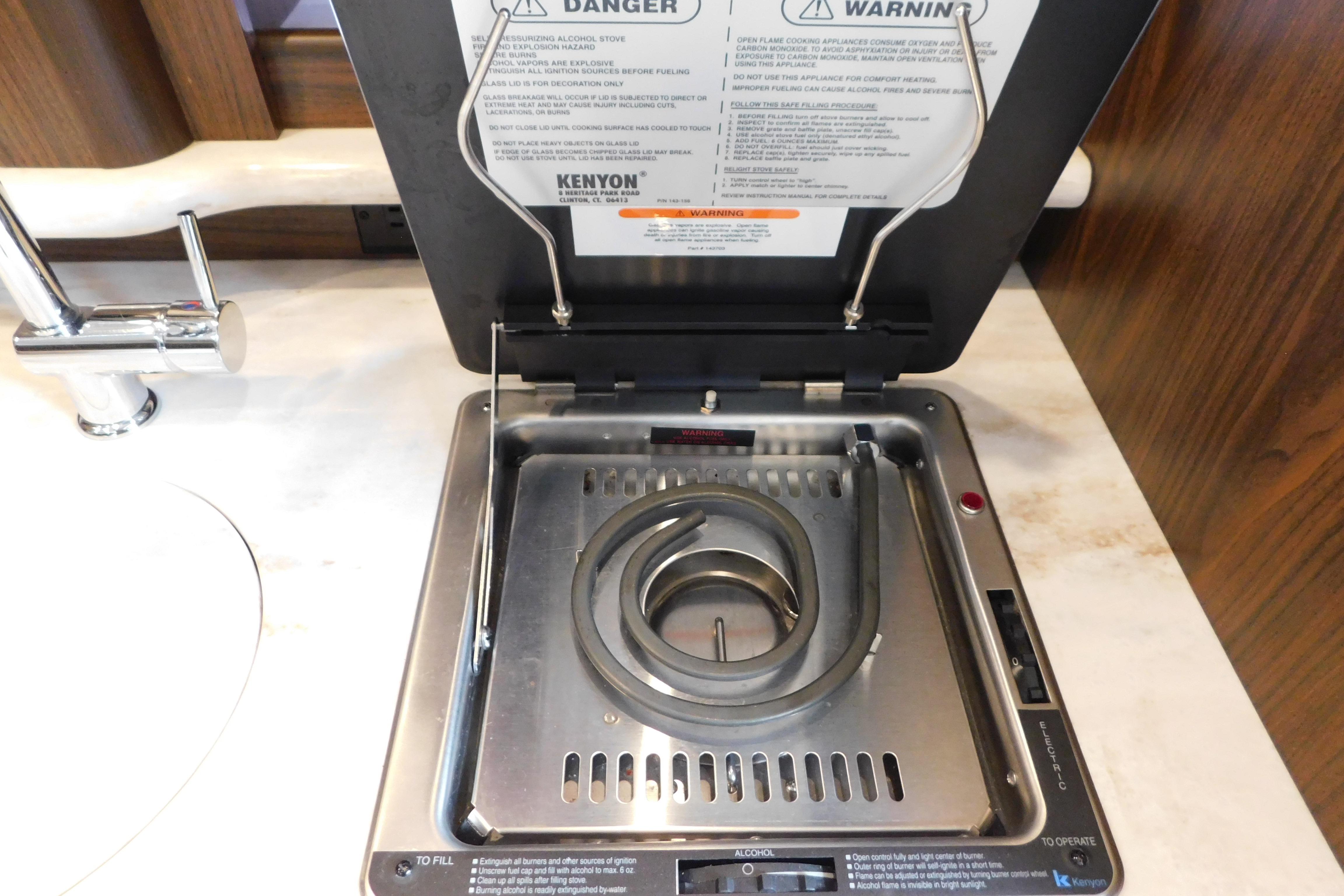 Built-in stove on 2017 Rinker EX 320 boat, featuring Kenyon electric cooktop.