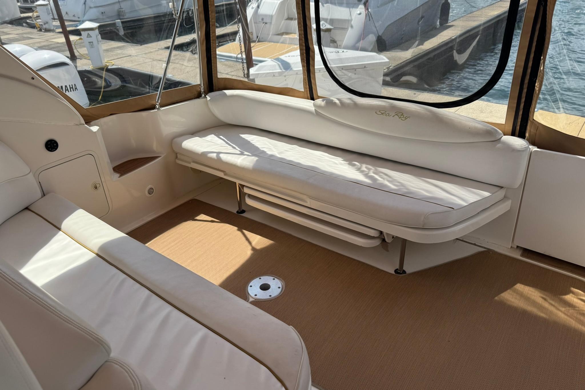 Interior of a 2001 Sea Ray 340 Sundancer yacht with white seating and marina view.