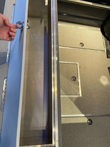 2024 Spartan 185 Astoria boat storage compartment with hand opening the lid.