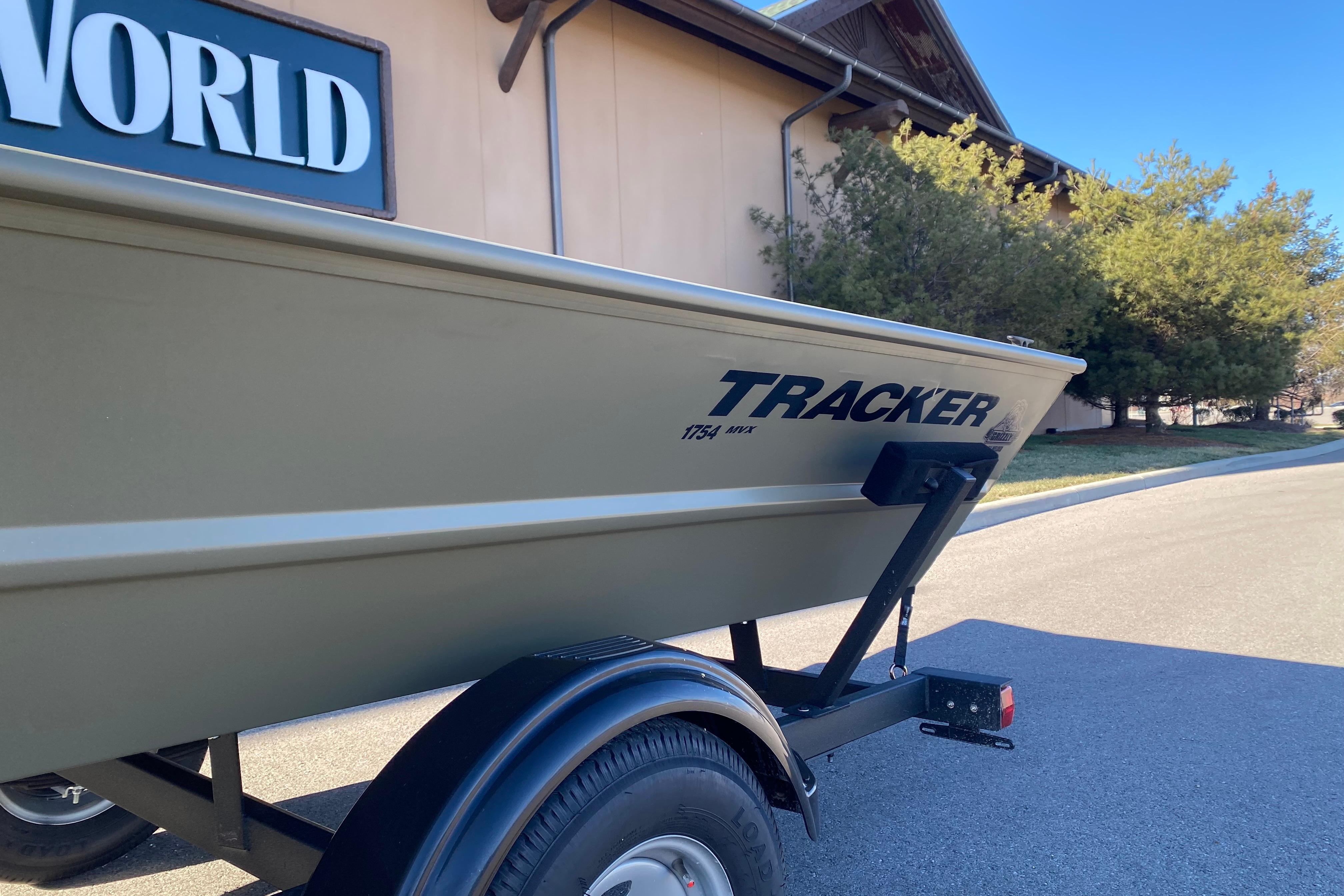 2026 Tracker Grizzly 1754 Utility boat on trailer, parked outdoors near building.