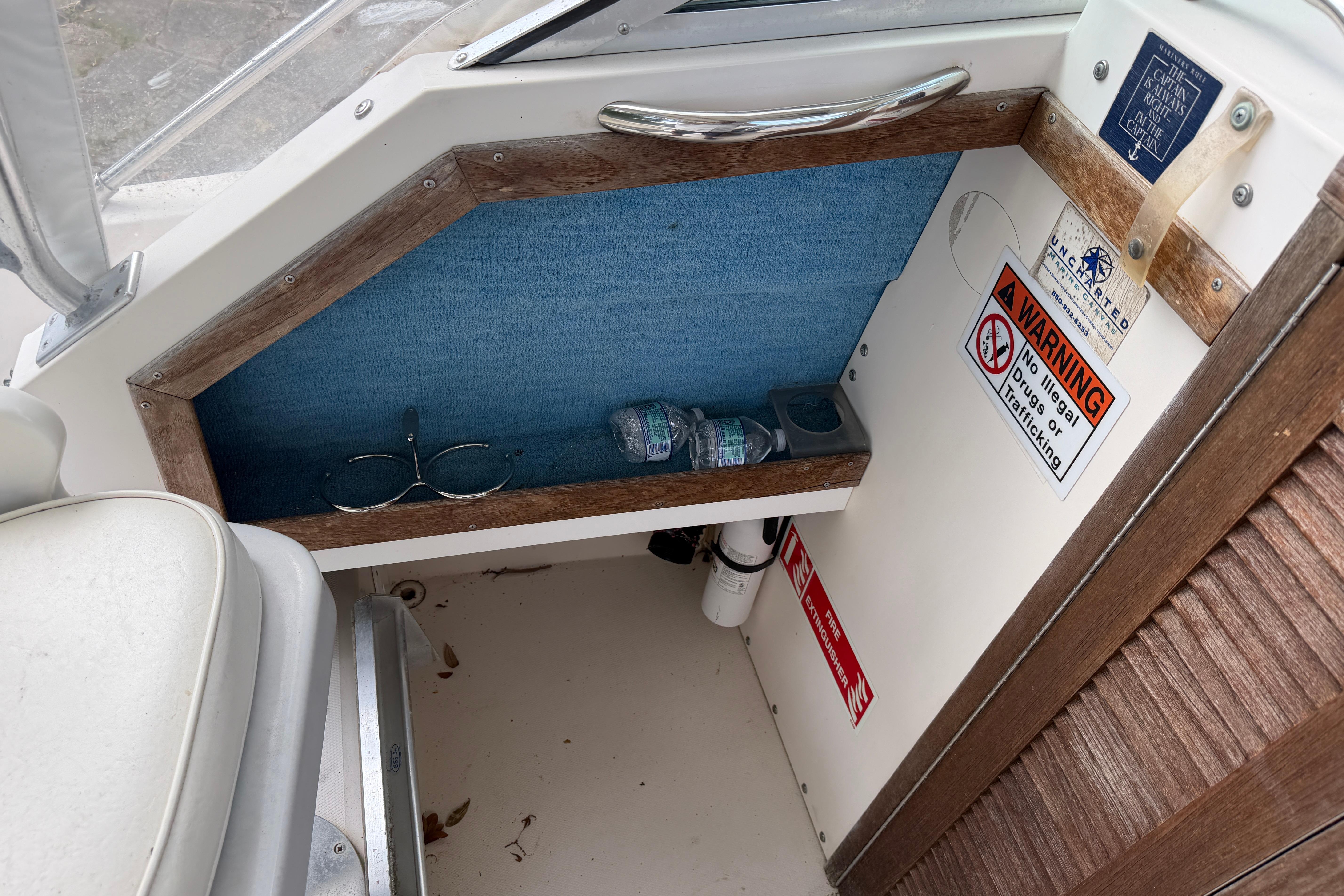 Interior of 1987 Grady-White Seafarer 226 boat with storage shelf and warning signs.