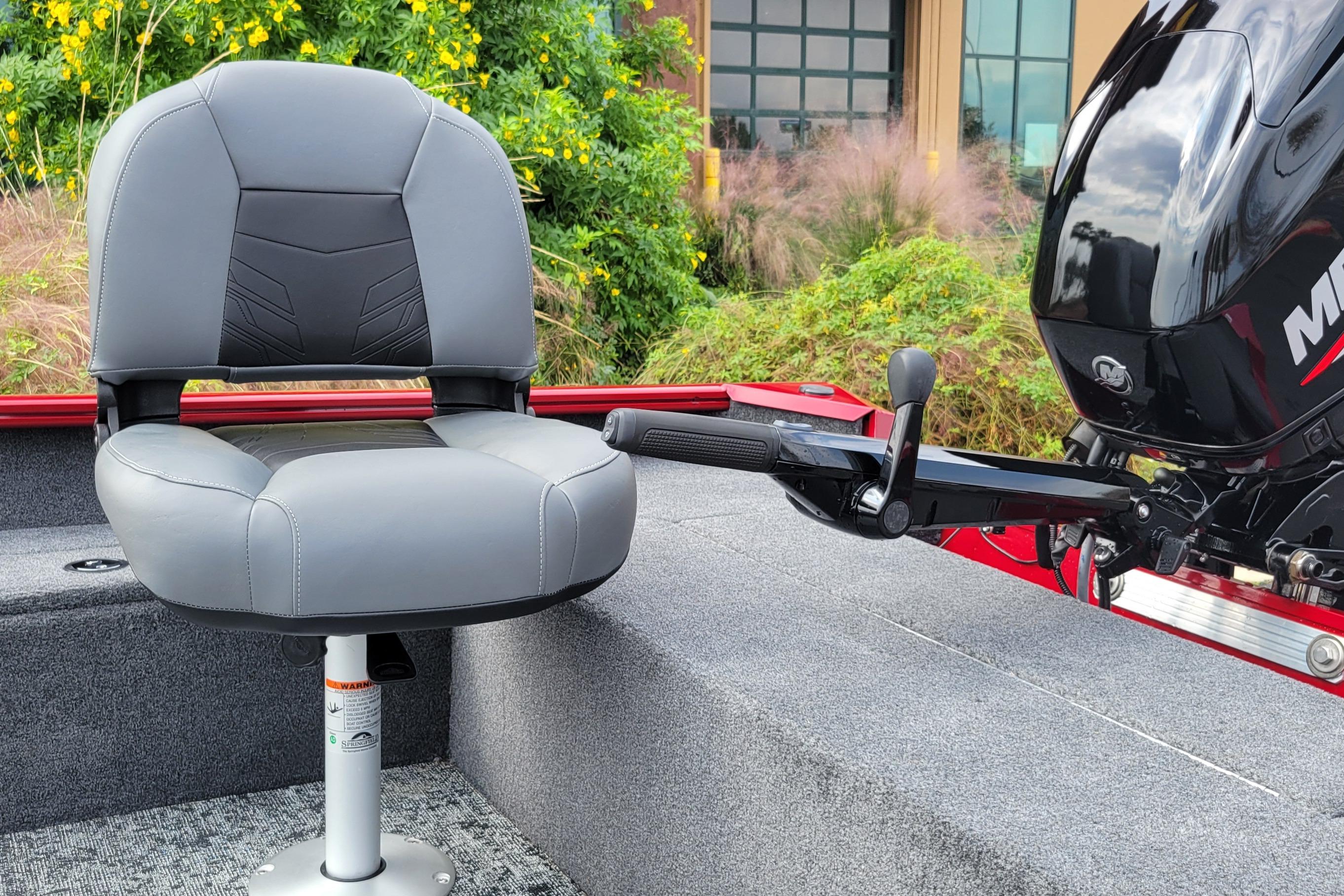 2025 Tracker Super Guide V-16 T boat seat and motor, surrounded by greenery.