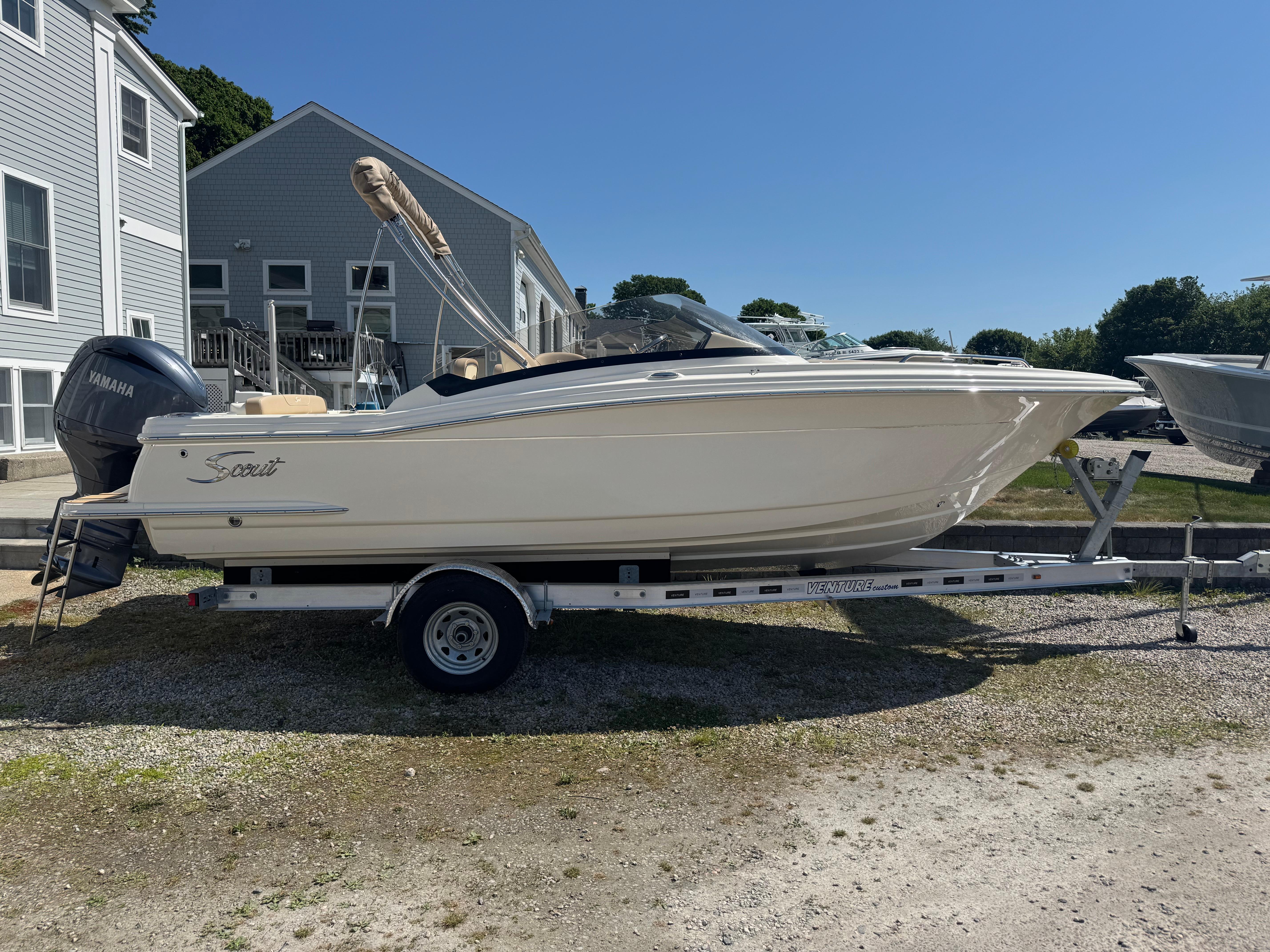 2025 Scout 215 Dorado boat on trailer, parked outdoors, with Yamaha engine.