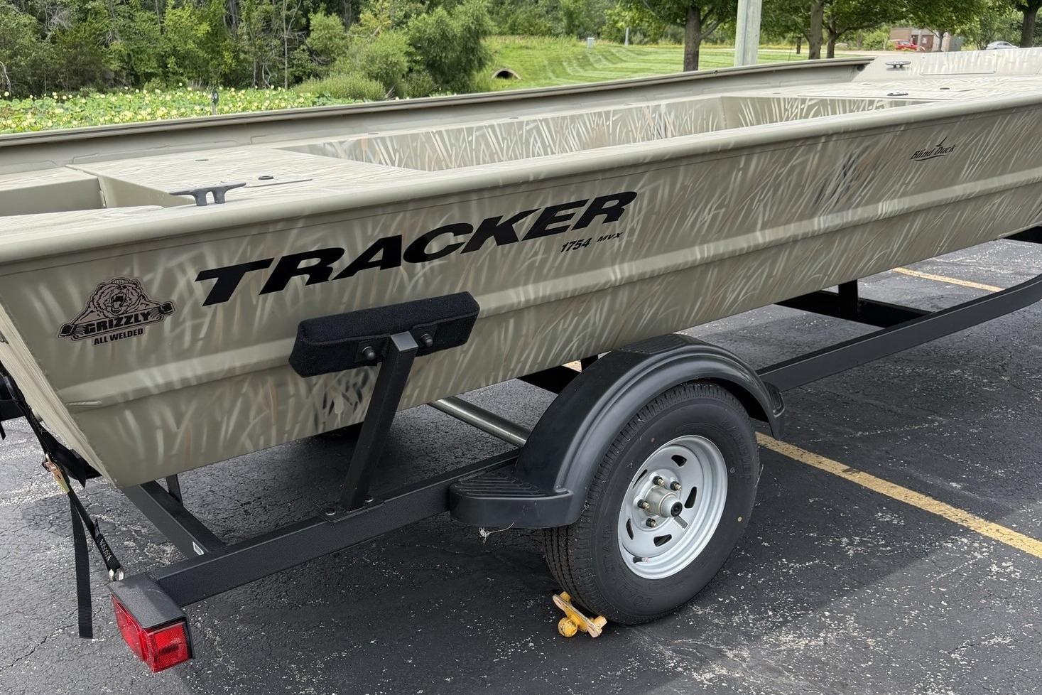 2025 Tracker Grizzly 1754 Jon boat on trailer, parked outdoors.