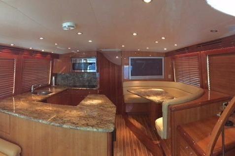 Luxurious interior of 2004 Hatteras 65 Convertible yacht with elegant wood finishes and granite countertops.