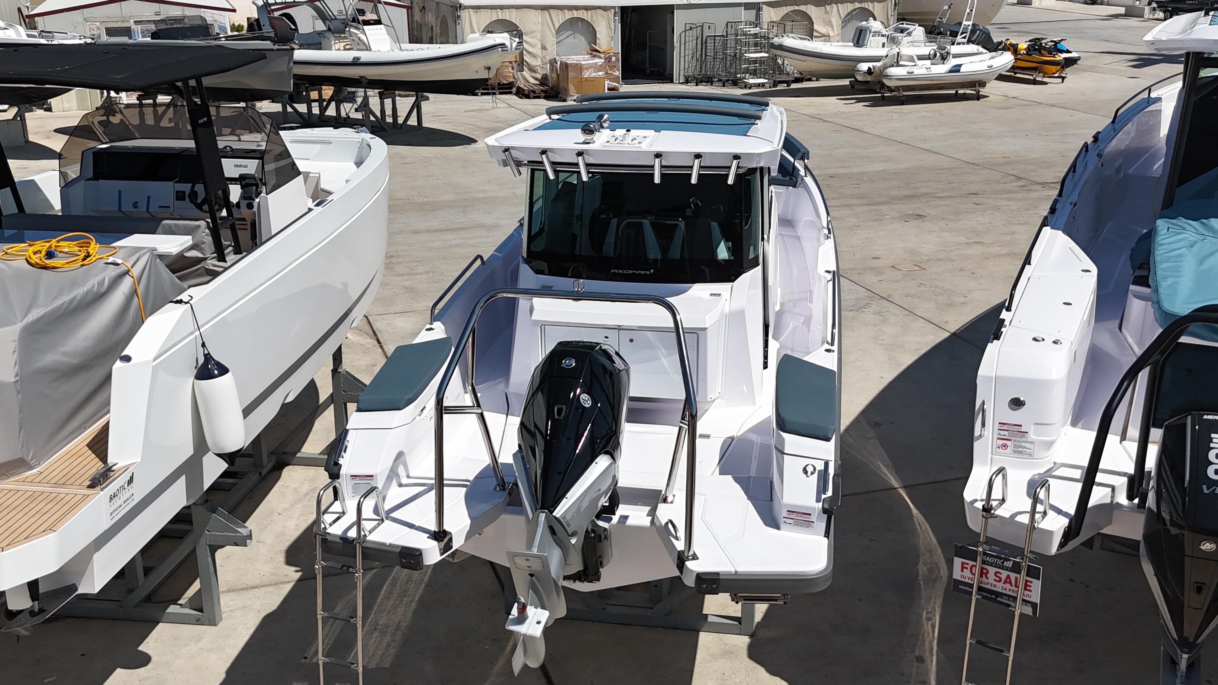 2024 Axopar 29 XC Cross Cabin boat displayed in a marina, rear view.
