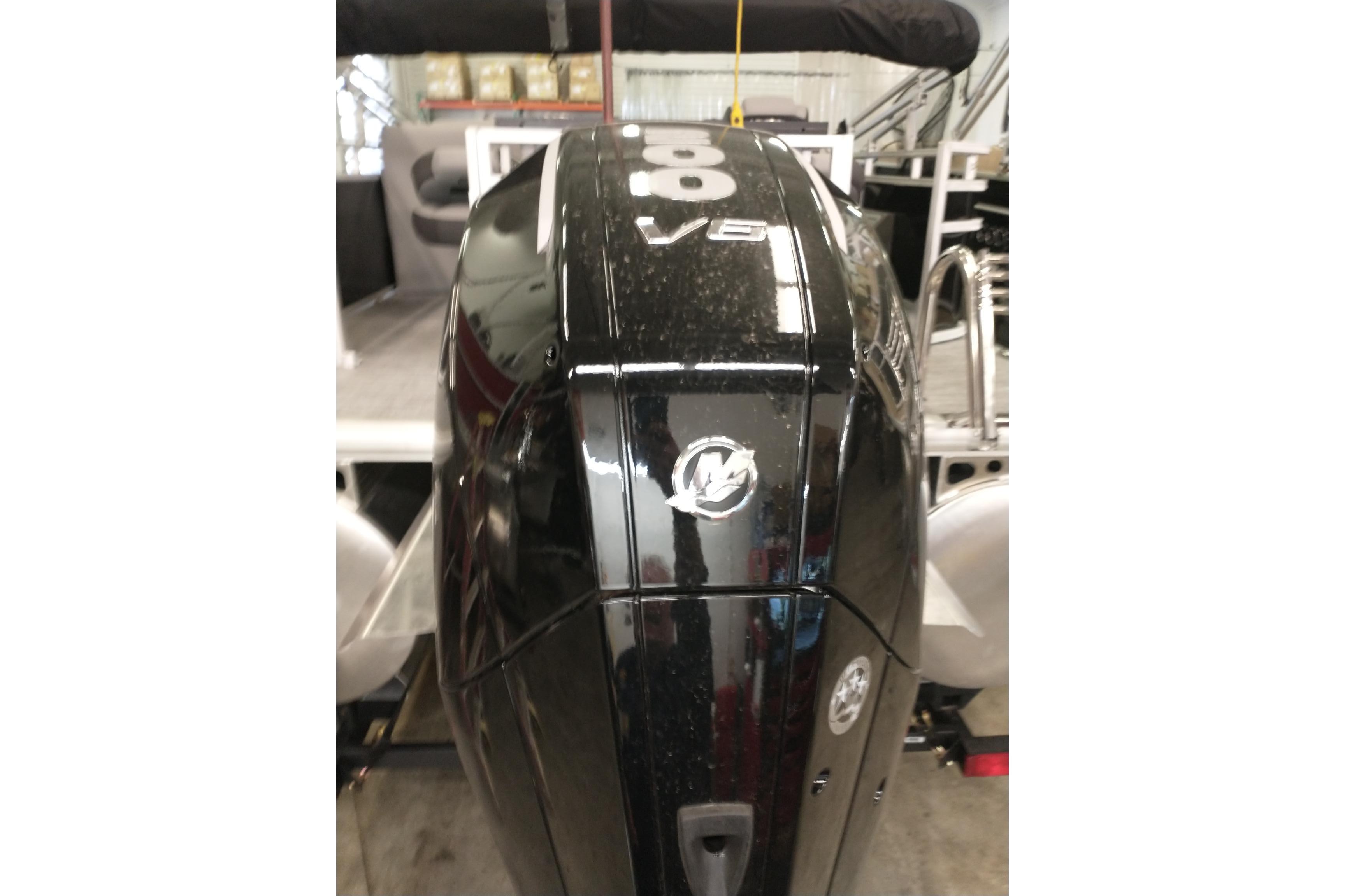 2026 Sun Tracker SportFish 22 XP3 with powerful V8 engine in a showroom.