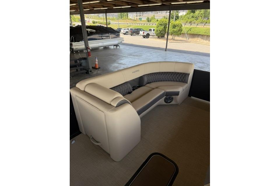 2025 Harris Sunliner 230 pontoon boat with luxurious seating under a covered dock.