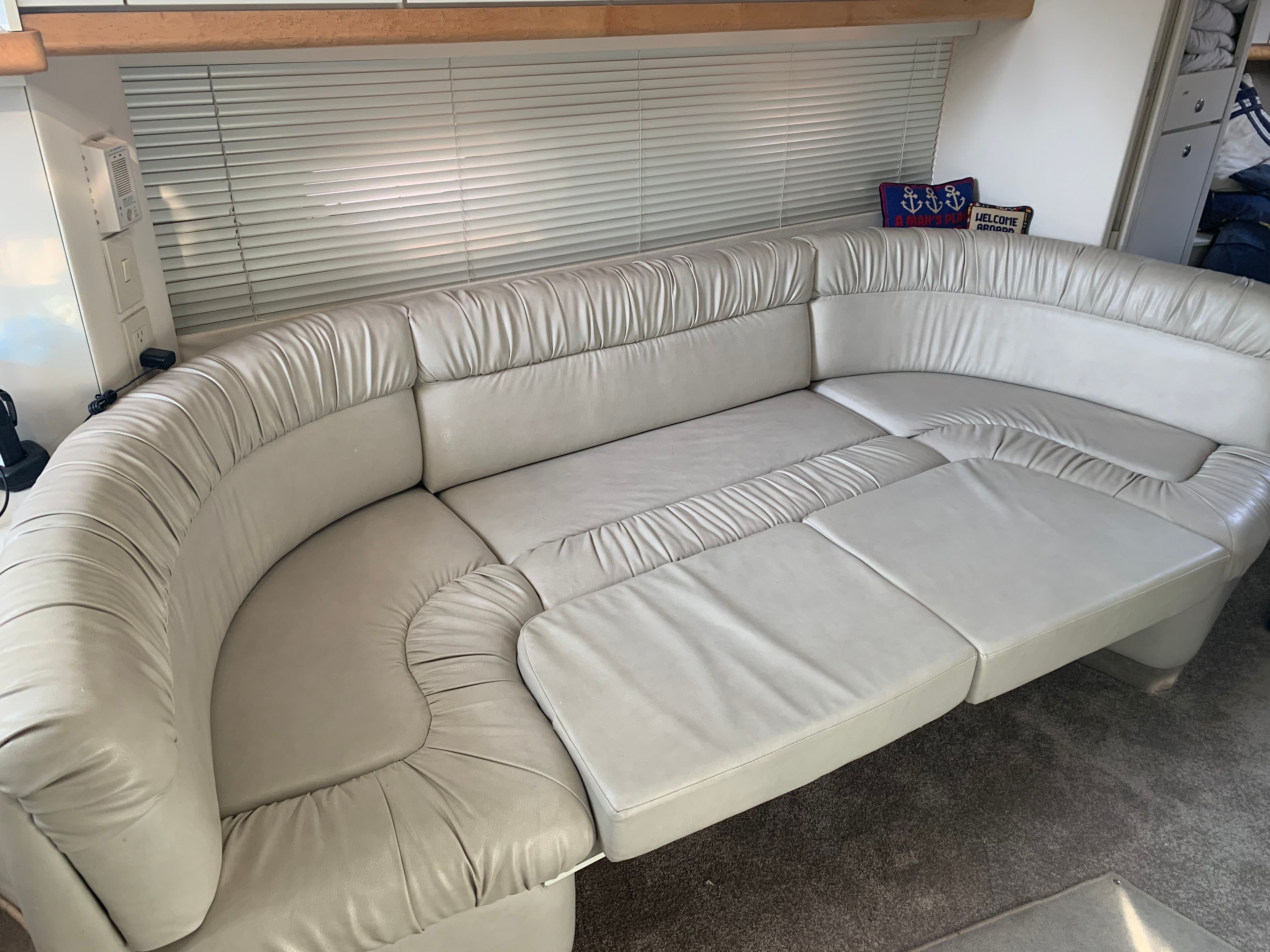 Interior of a boat featuring a large, cream-colored leather couch.
