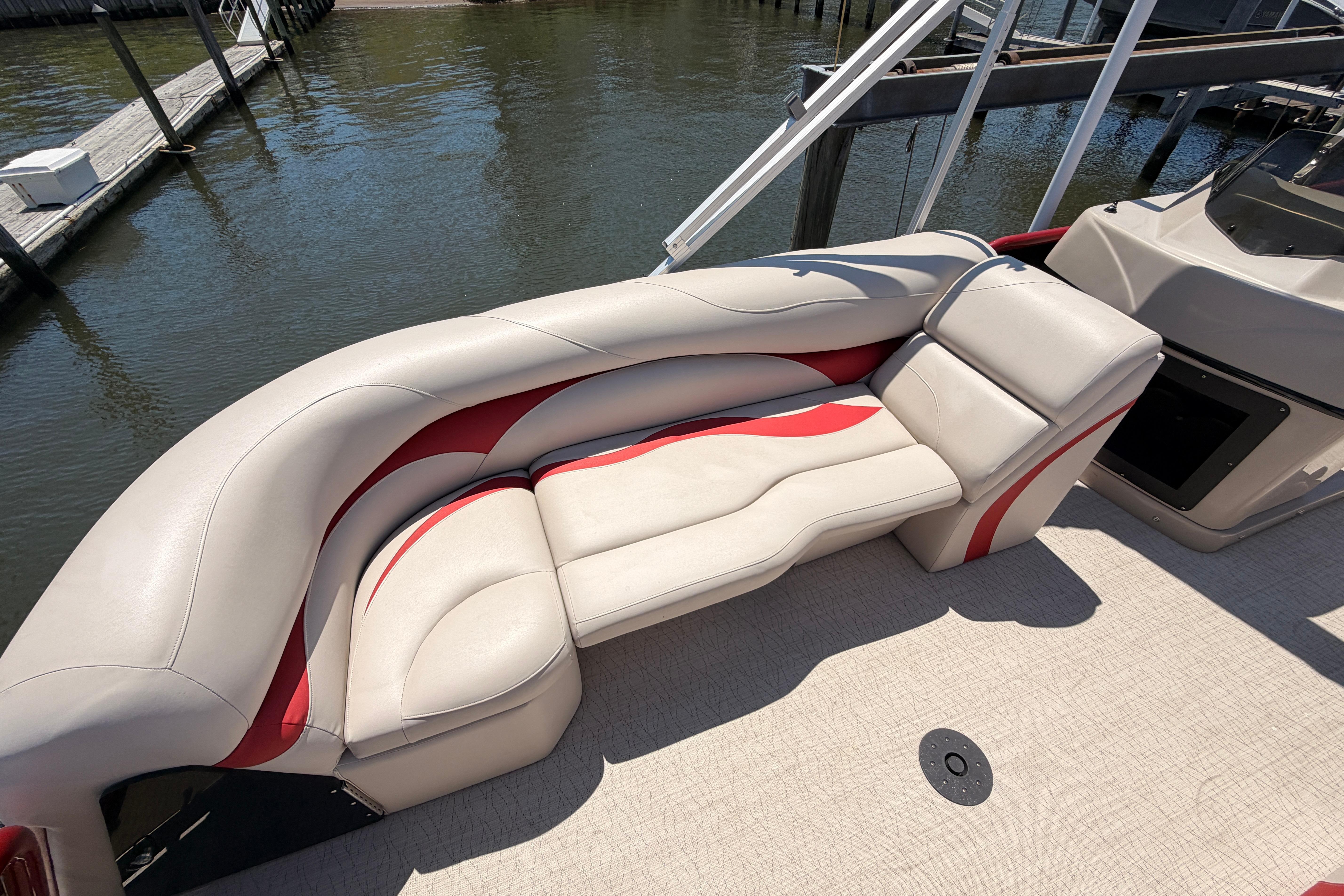 2022 Aloha Pontoon 23 Club Series with beige and red seating by the water.