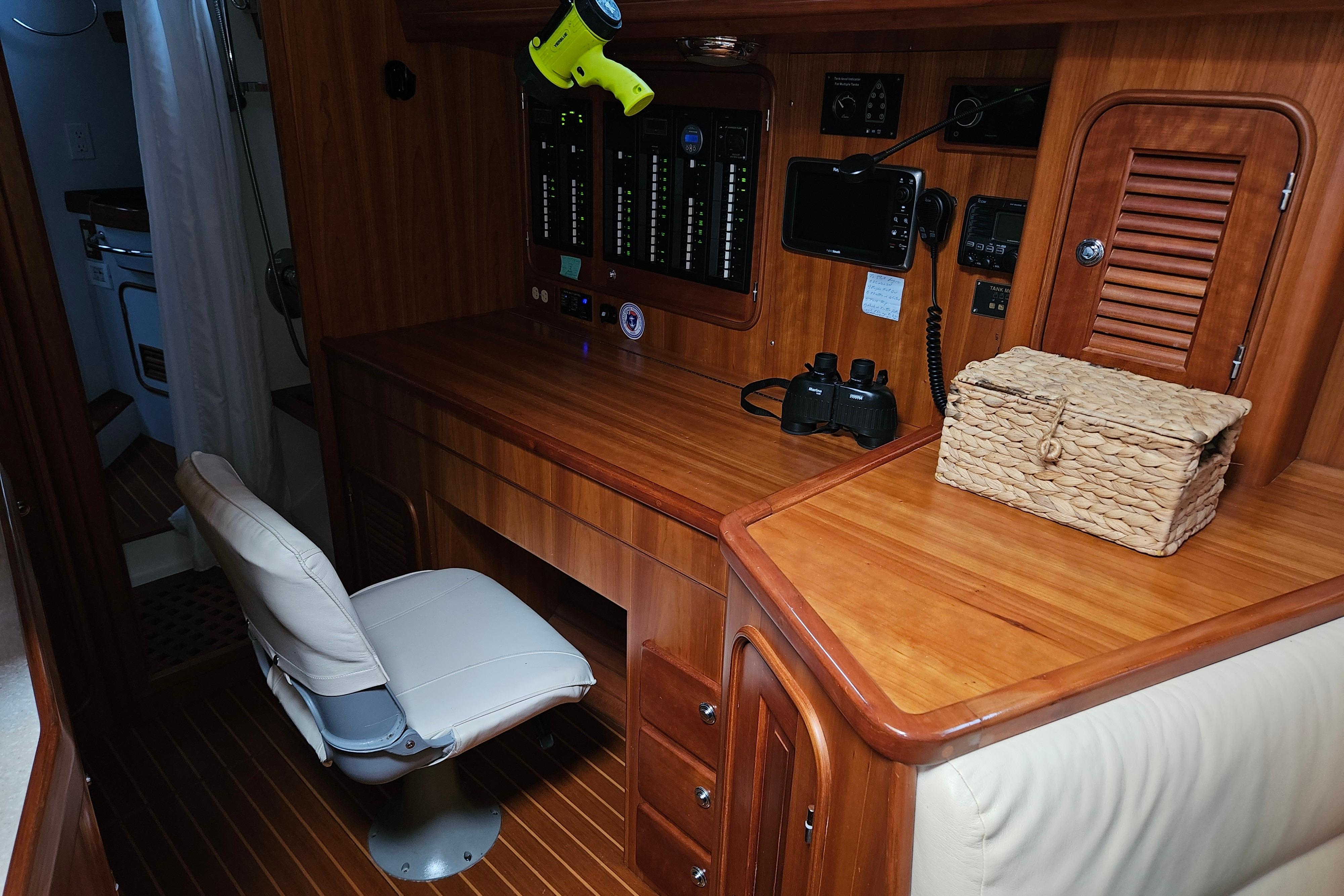 Interior of 2013 Passport 470 Center Cockpit with navigation station and wooden cabinetry.