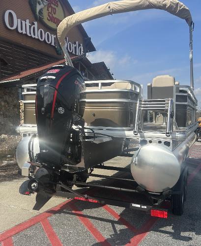 2025 Sun Tracker SportFish 22 DLX pontoon boat parked outside Outdoor World.