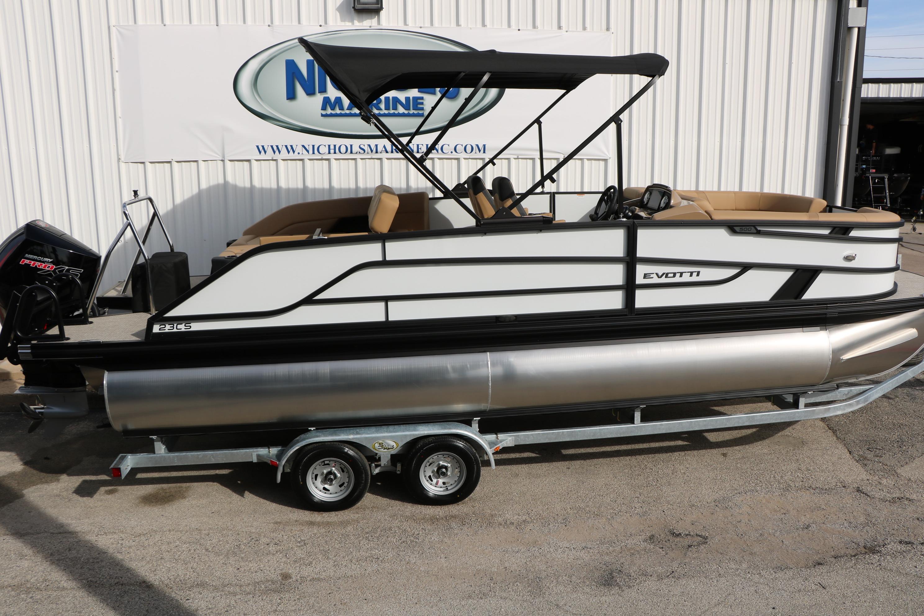 2026 Evotti 523CS pontoon boat on trailer, parked outside marine dealership.