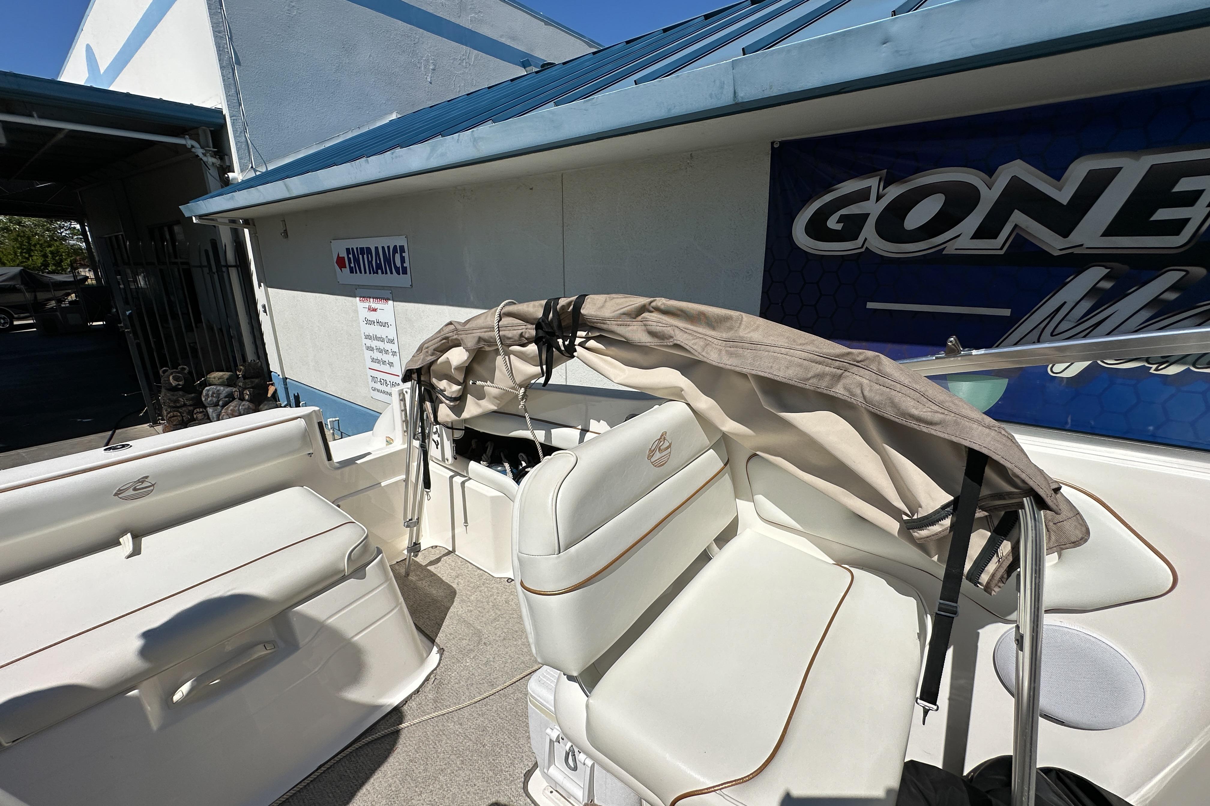 1998 Sea Ray 215 Express Cruiser interior with white seating and folded canopy.
