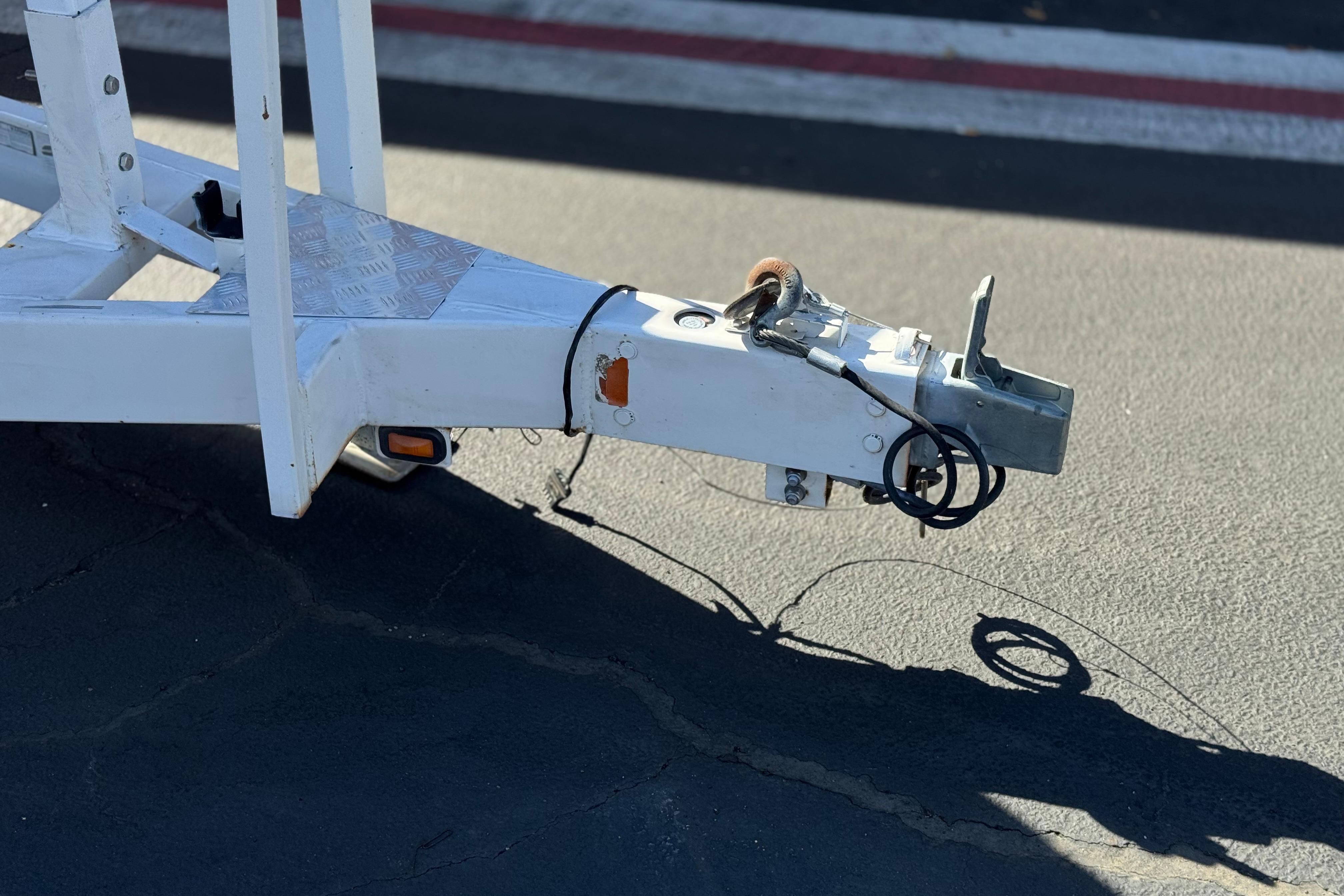 Trailer hitch of a 2011 Chaparral 267 SSX boat on asphalt pavement.