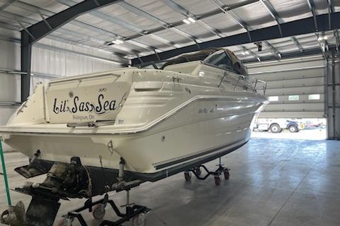 1998 Searay 270 Sundancer boat in a garage, rear view, on a trailer.