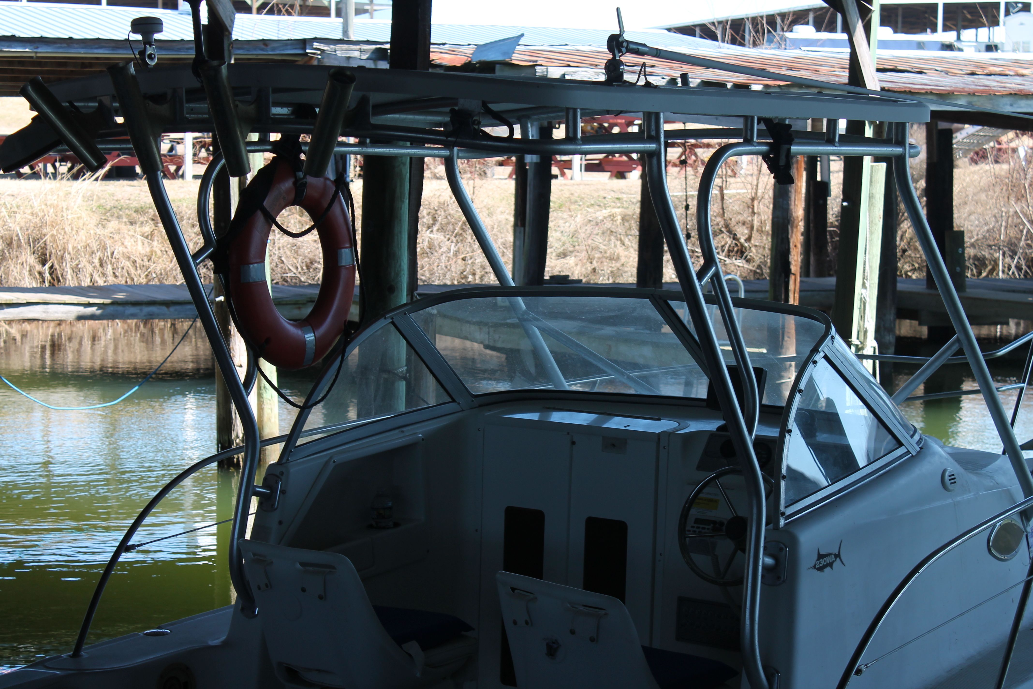 2004 Sea Fox 230 Walk Around boat docked with lifebuoy.