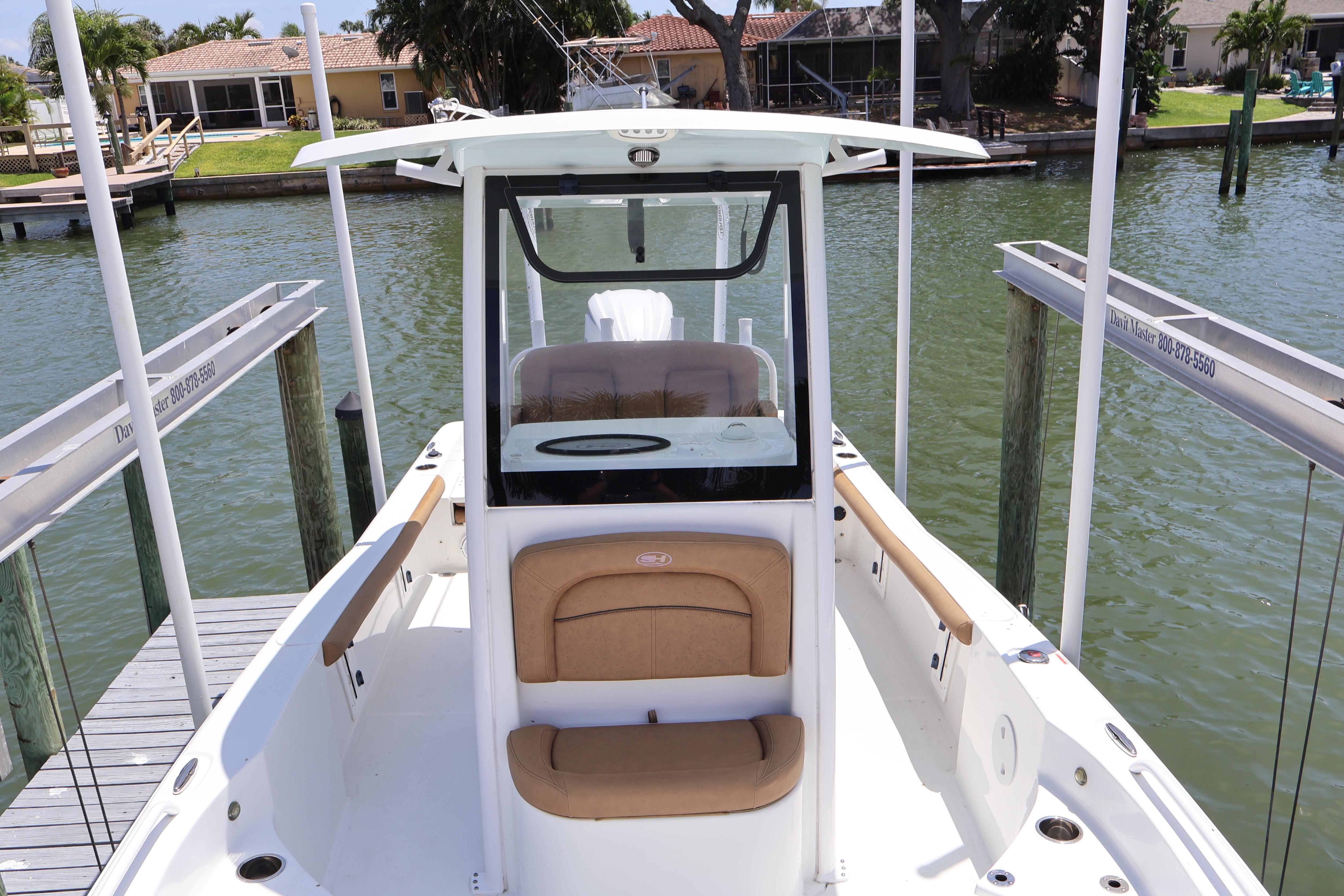 2022 Sea Hunt BX 25 FS boat docked by waterfront homes.