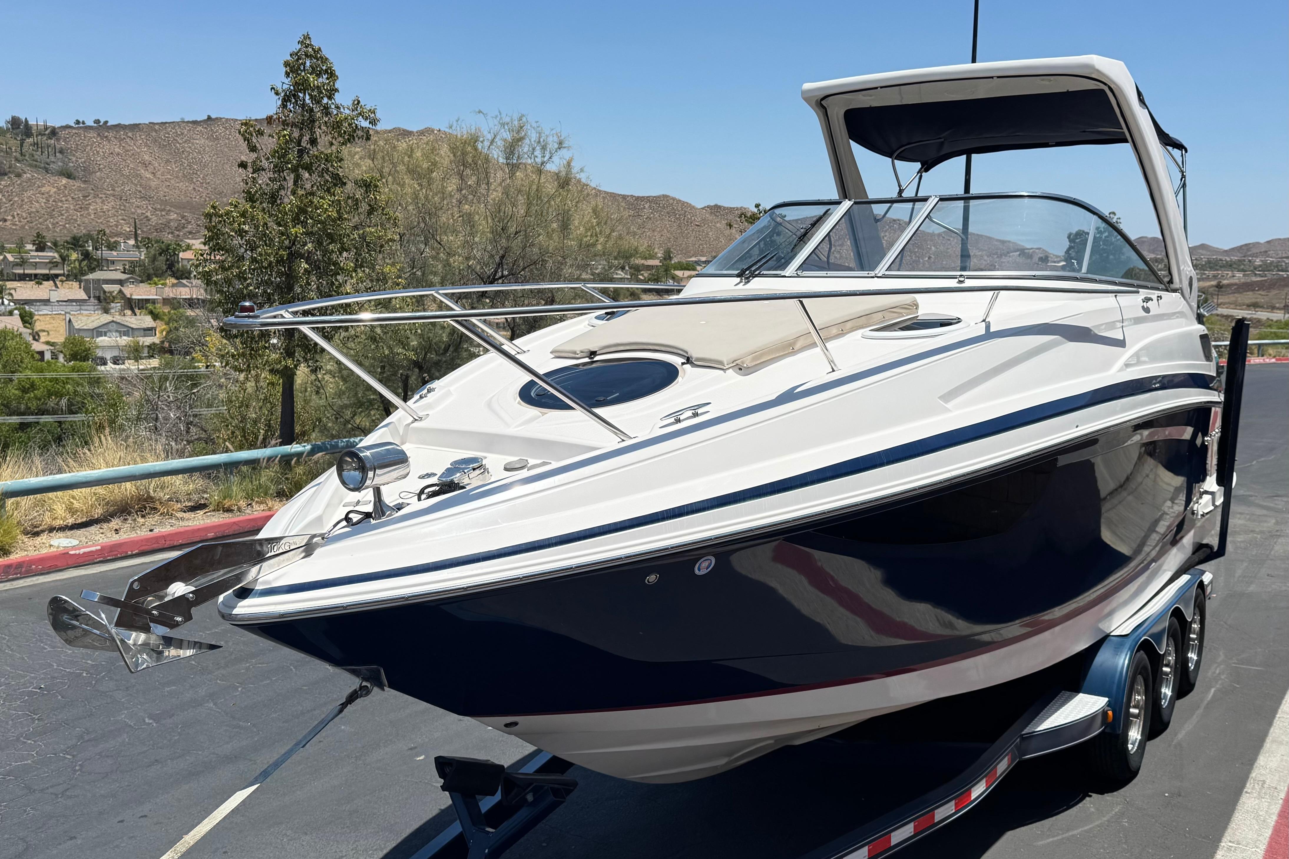2013 Regal 28 Express boat on trailer, parked outdoors with scenic background.