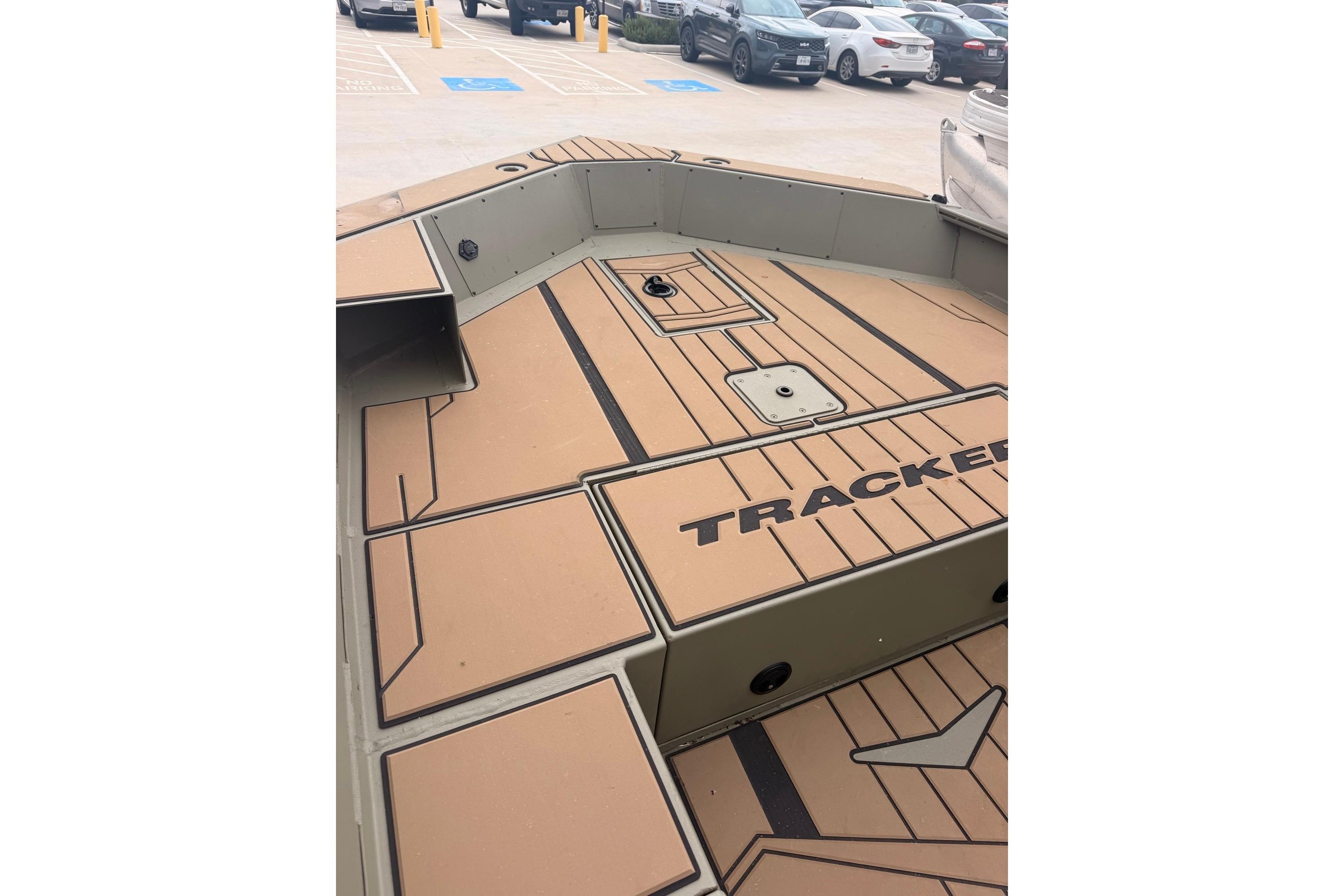 2026 Tracker Grizzly 1756 MARSH boat interior with tan deck in parking lot.
