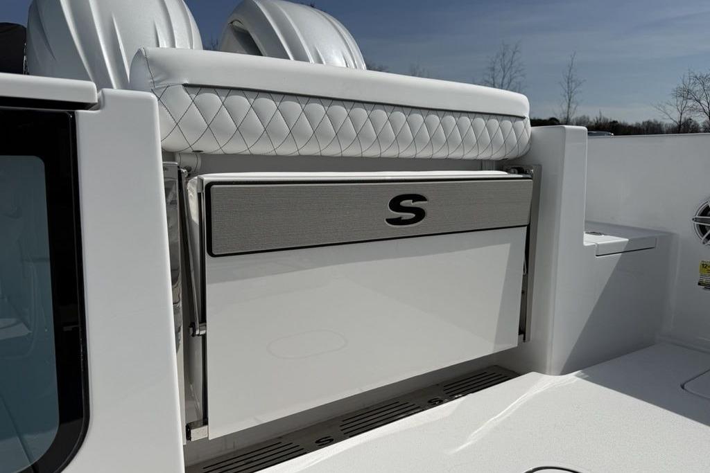 2026 Sportsman Open 252 Center Console boat interior with quilted seating and storage compartment.