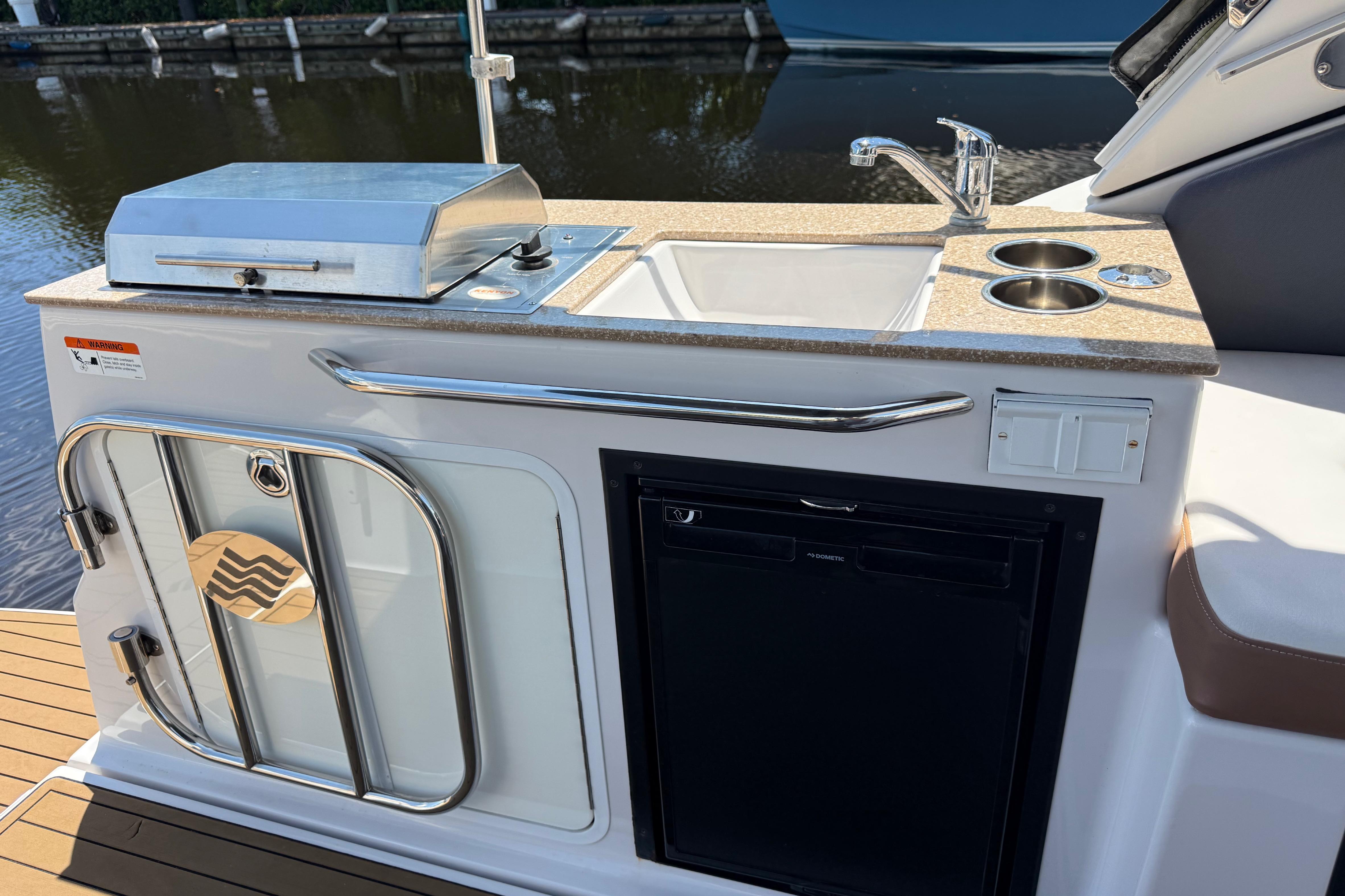 2017 Four Winns V275 boat kitchenette with sink, grill, and storage.