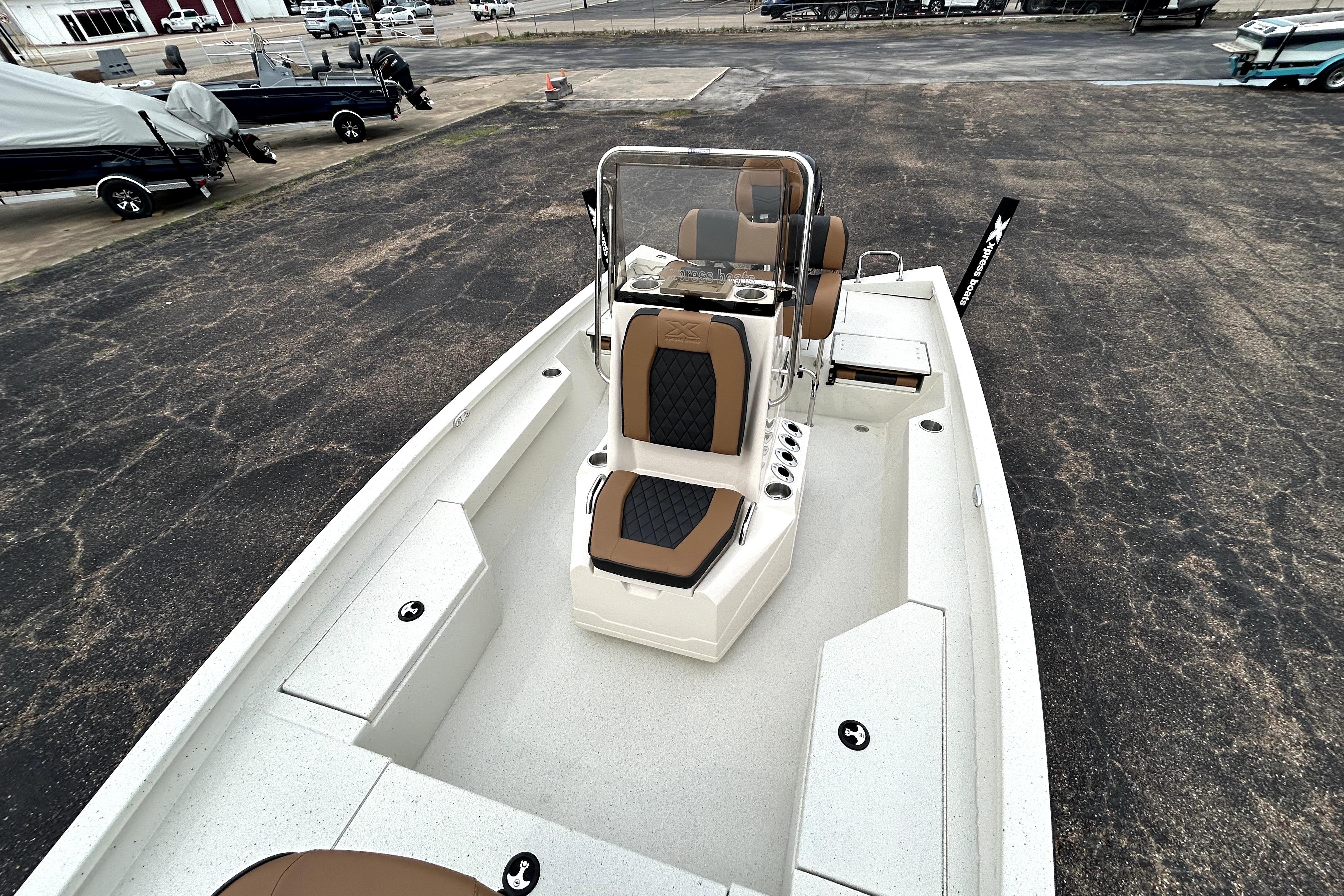 2026 Xpress H20B Bay boat with tan and black seating, parked on asphalt.
