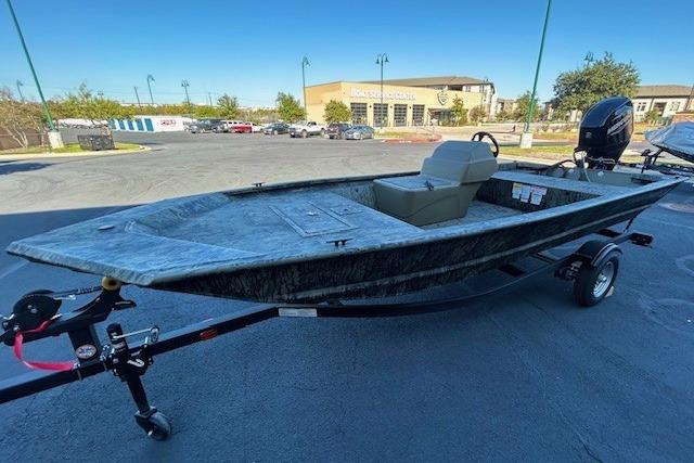 2026 Tracker Grizzly 1648 SC boat on trailer in parking lot.