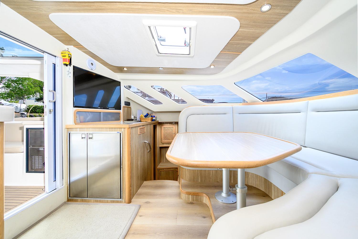 Luxurious interior of 2019 Knysna 500SE yacht with modern dining area and panoramic windows.
