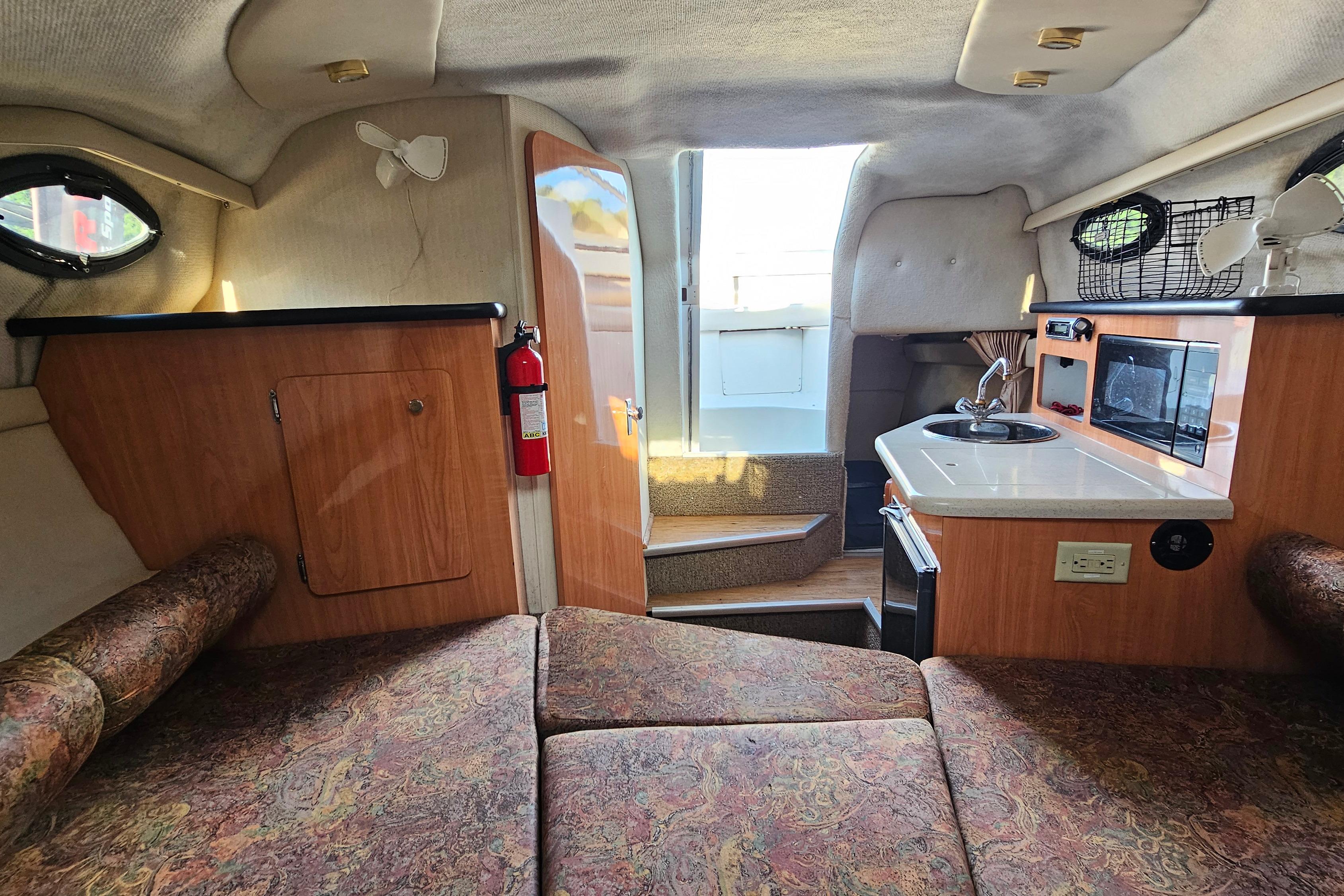 Interior of a 1999 Regal Commodore 258 boat with kitchenette and seating area.