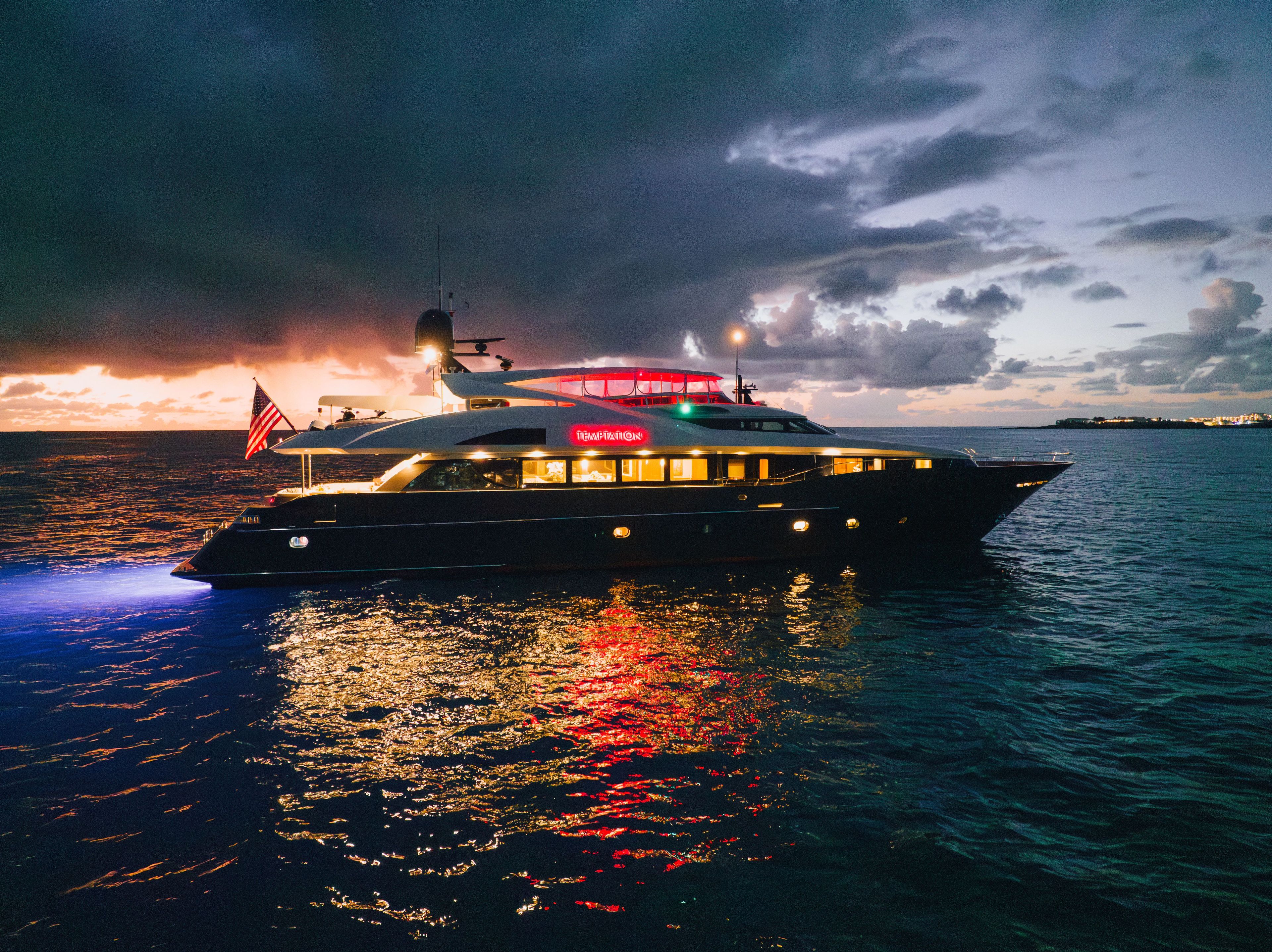 A luxurious Palmer Johnson yacht, Raised Pilothouse model, 2005, cruising on water at sunset.