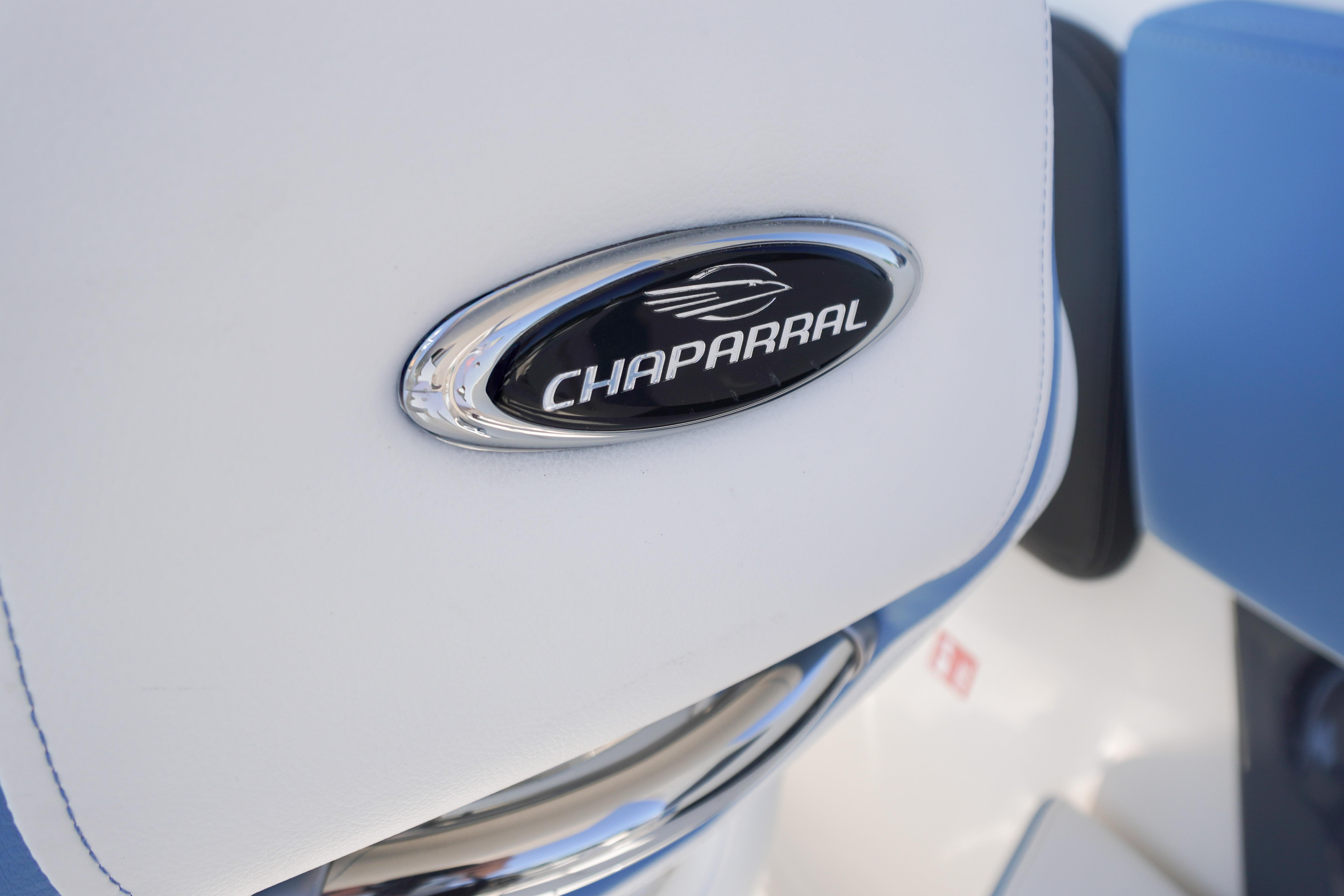 Close-up of 2026 Chaparral 270 OSX logo on white and blue upholstery.
