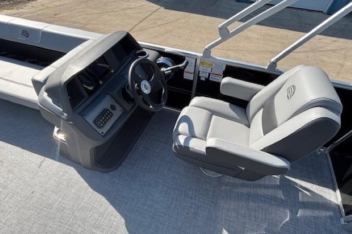 2026 Sun Tracker Party Barge 18 DLX interior with steering console and captain's chair.