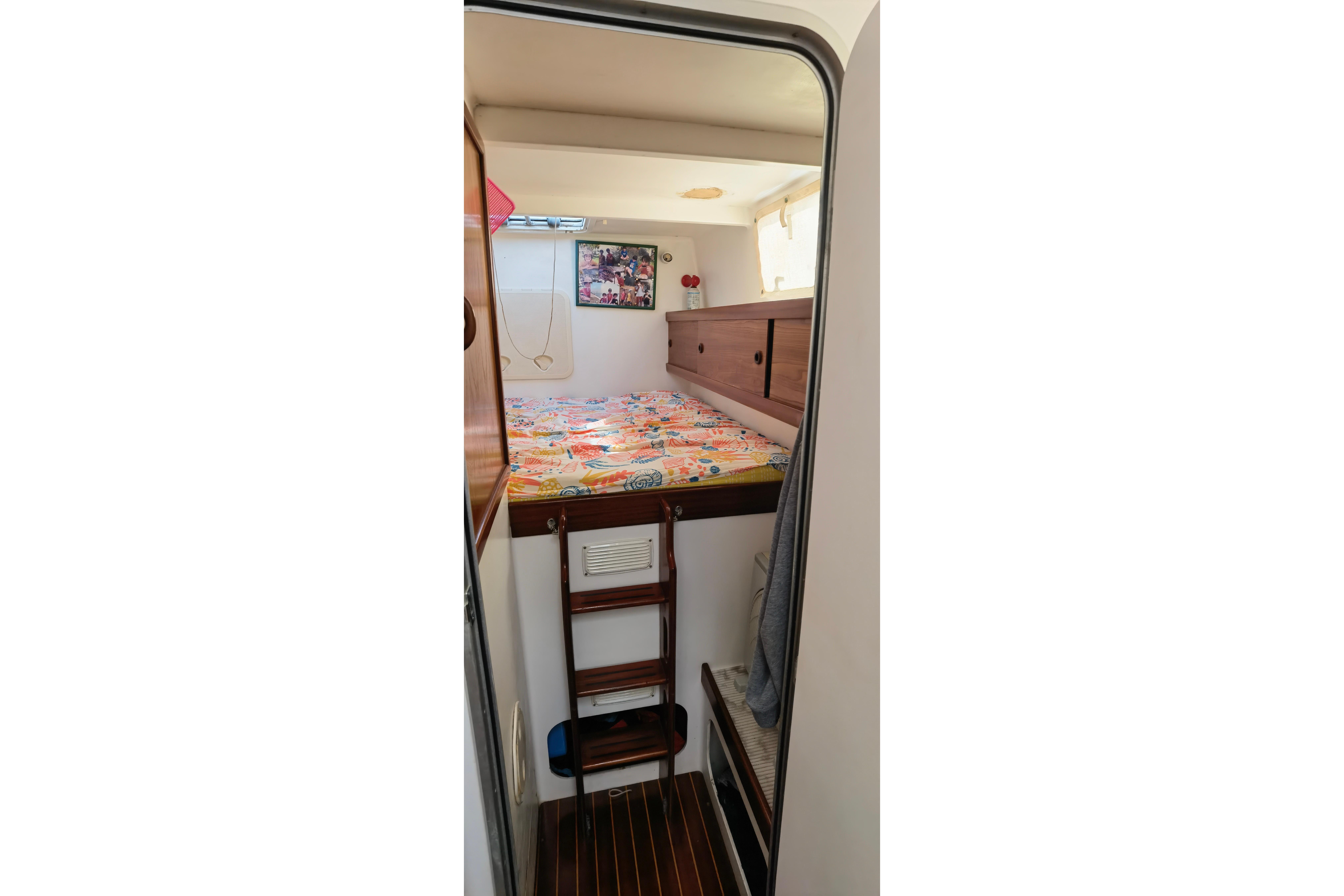 Cozy cabin interior of 1997 Naval Force 3 Tropic 56 yacht with colorful bedding.